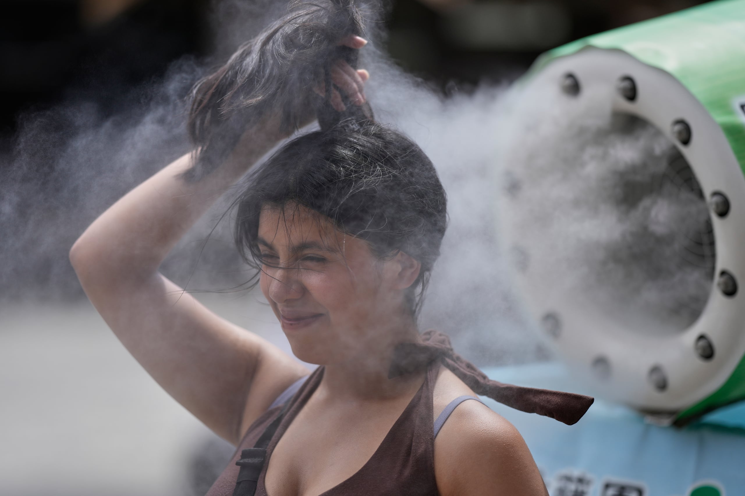 Una persona se refresca en una unidad de enfriamiento durante un caluroso día en el templo budista Sensoji, el 7 de agosto de 2026, en el distrito de Asakusa, en Tokio. (AP Foto/Eugene Hoshiko, Archivo)