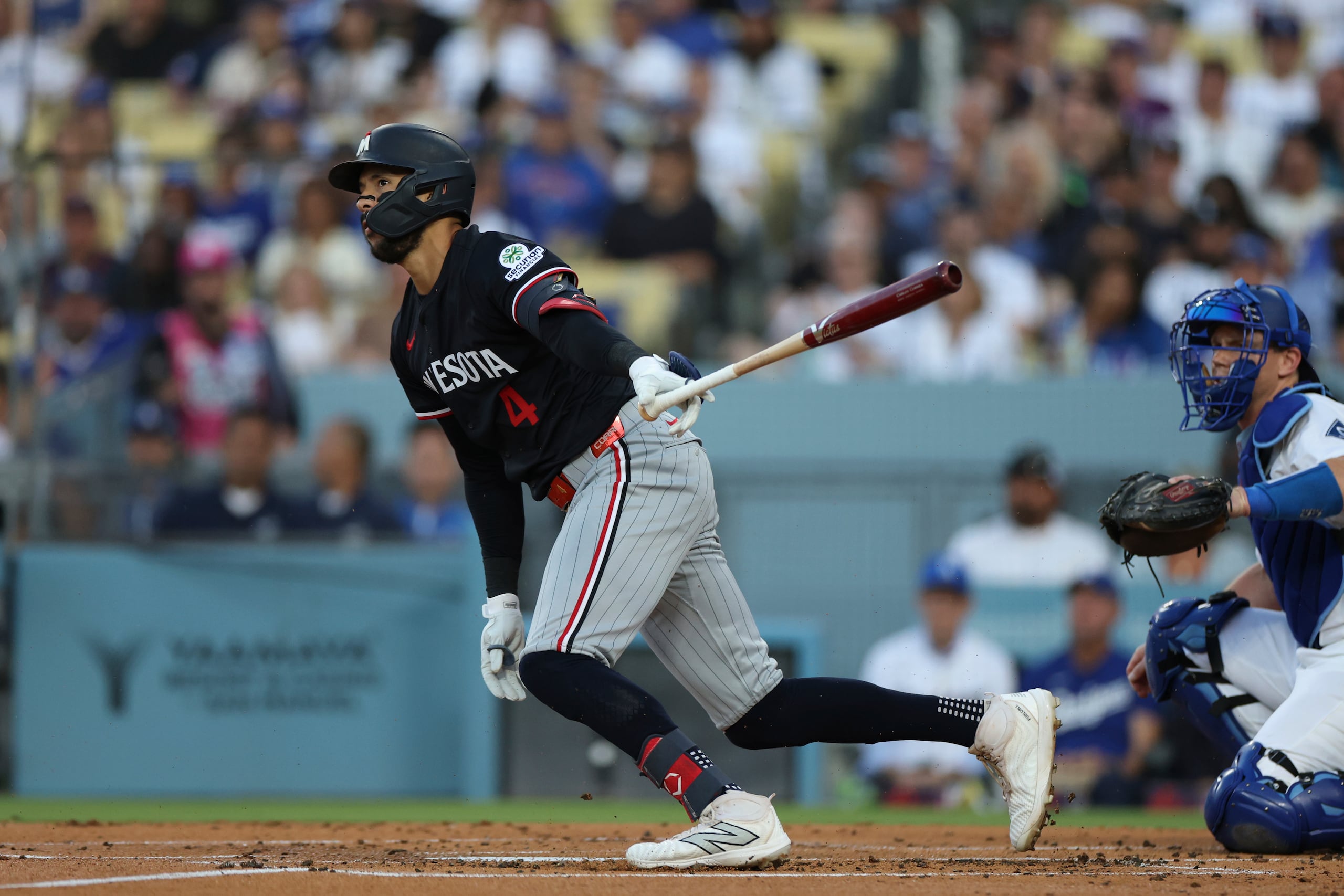 El puertorriqueño Carlos Correa de los Mellizos de Minnesota observa su sencillo en la segunda entrada ante los Dodgers de Los Ángeles el martes 22 de julio del 2025. (AP Foto/Eric Thayer)