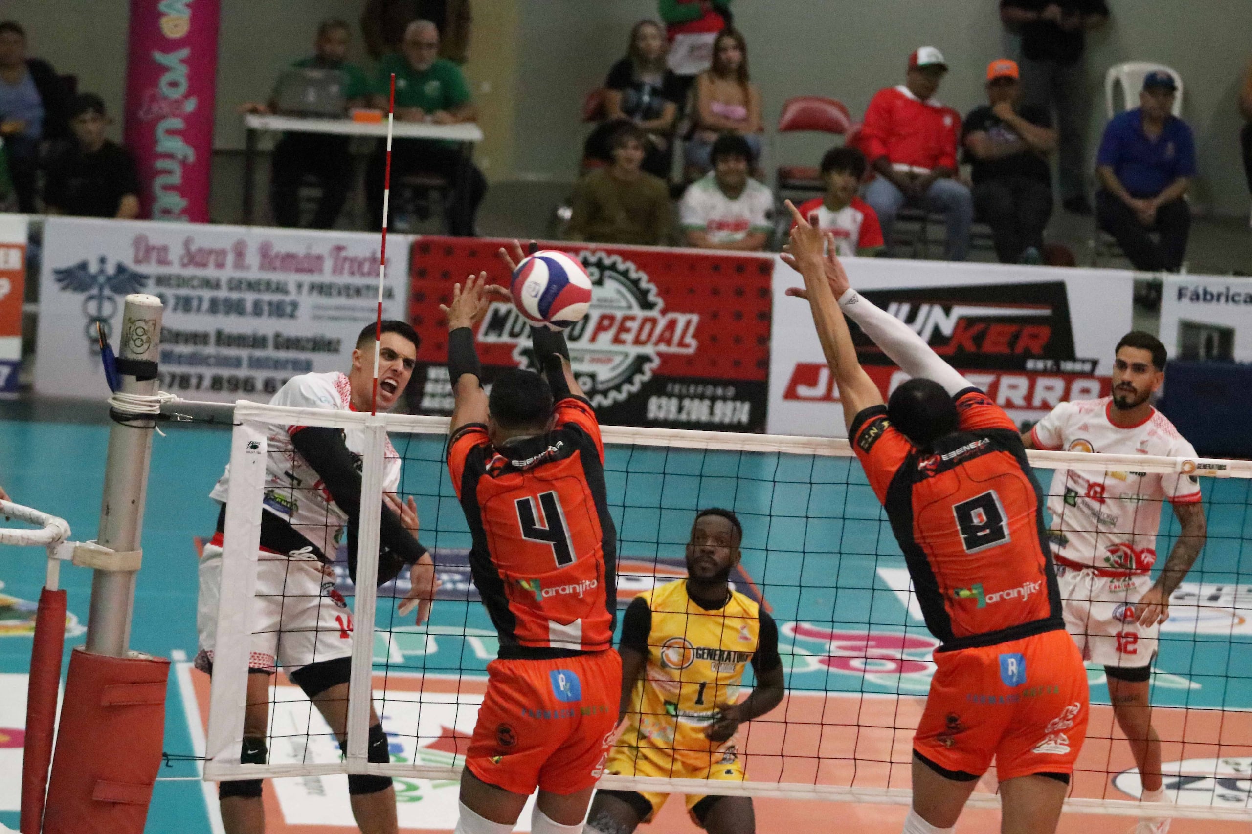Pelegrín Vargas, hijo, ataca contra el doble bloqueo de Naranjito en el primer juego de la serie semifinal que ganaron los Caribes de San Sebastián.