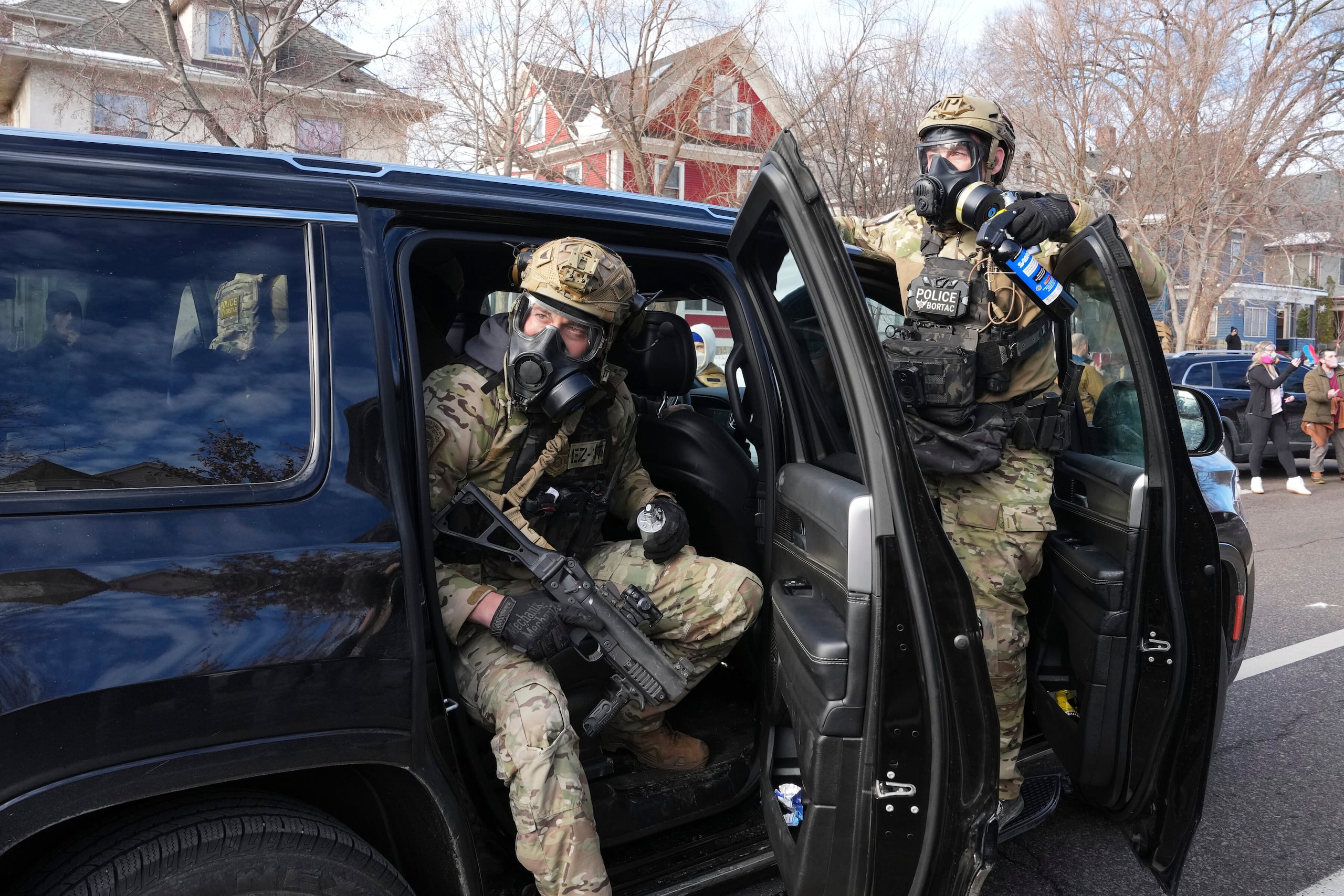 Agentes federales se preparan para lanzar gas lacrimógeno a una multitud durante una protesta el lunes 12 de enero de 2026 en Minneapolis (AP Foto/Adam Gray)