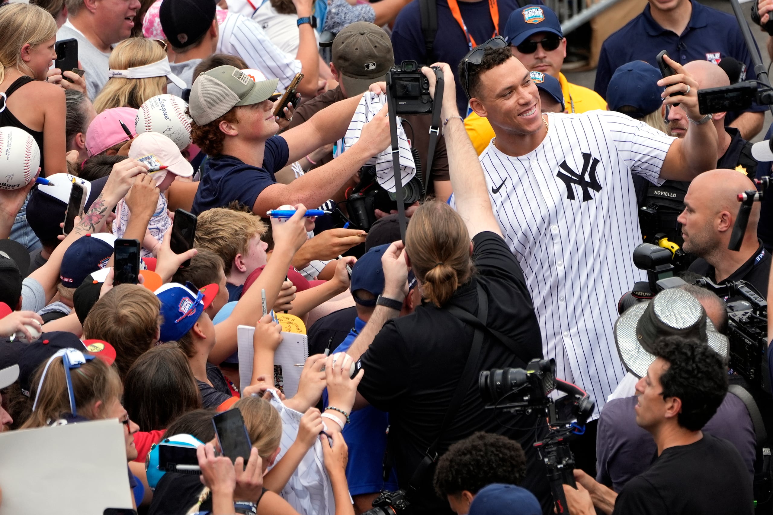 Aaron Judge, de los Yankees de Nueva York, se toma una selfie con el teléfono celular de un fanático mientras llega con los Yankees de Nueva York al Complejo de la Serie Mundial de Pequeñas Ligas para ver el torneo de la Serie Mundial de Pequeñas Ligas en South Williamsport, Pensilvania, el domingo 18 de agosto de 2024. (AP Foto/Tom E. Puskar)