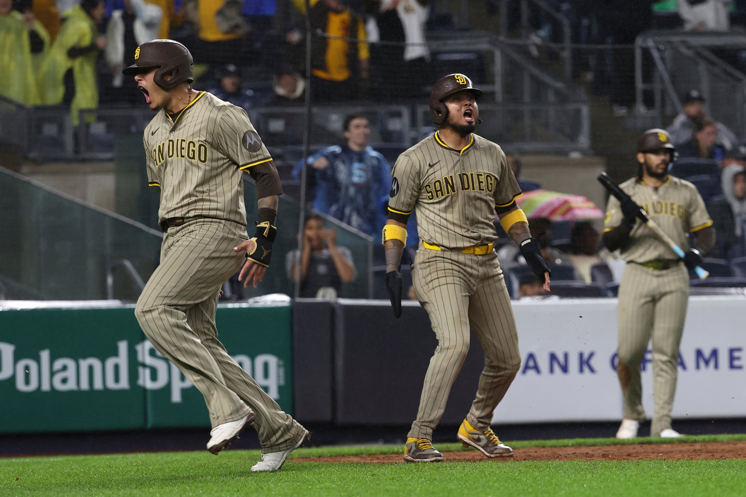 Manny Machado, izquierda, y Luis Arráez, centro, de los Padres de San Diego, reaccionan después de anotar con un sendillo de Xander Bogaerts durante la octava entrada del juego de béisbol de Grandes Ligas frente a los Yankees de Nueva York, el lunes 5 de mayo de 2025, en Nueva York. (AP Foto/Pamela Smith)