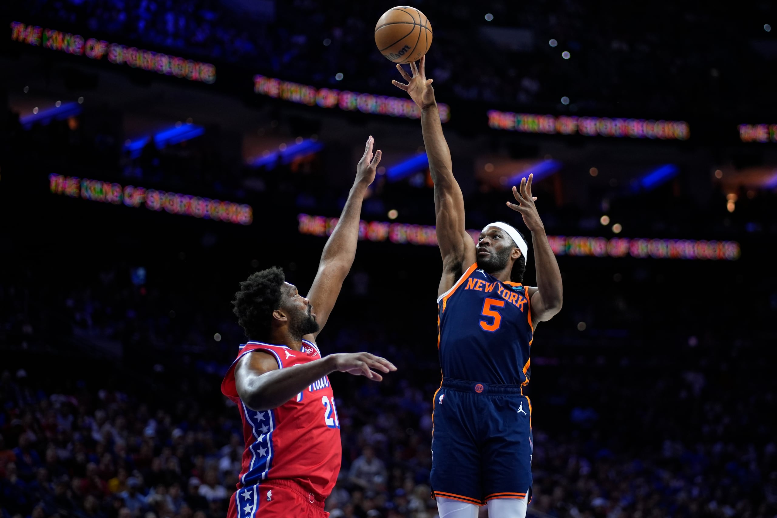 Precious Achiuwa lanza un intento sobre la defensa de Joel Embiid.