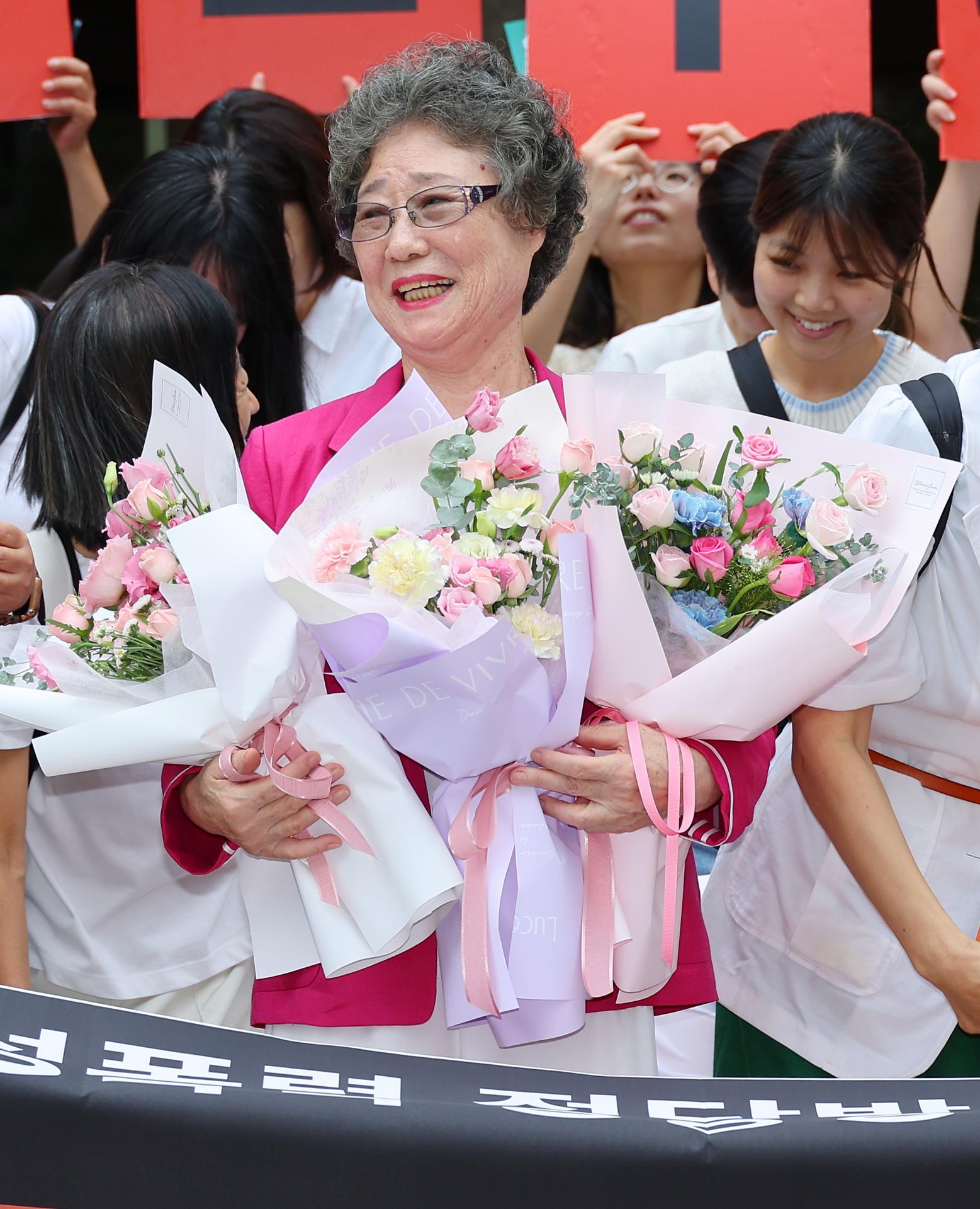 Choi Mal-ja recibe ramos de flores en un tribunal de distrito en Busan, Corea del Sur, el 10 de septiembre de 2025, después de que el tribunal la absolviera de los cargos en un histórico nuevo juicio, reconociendo su acción como defensa propia.