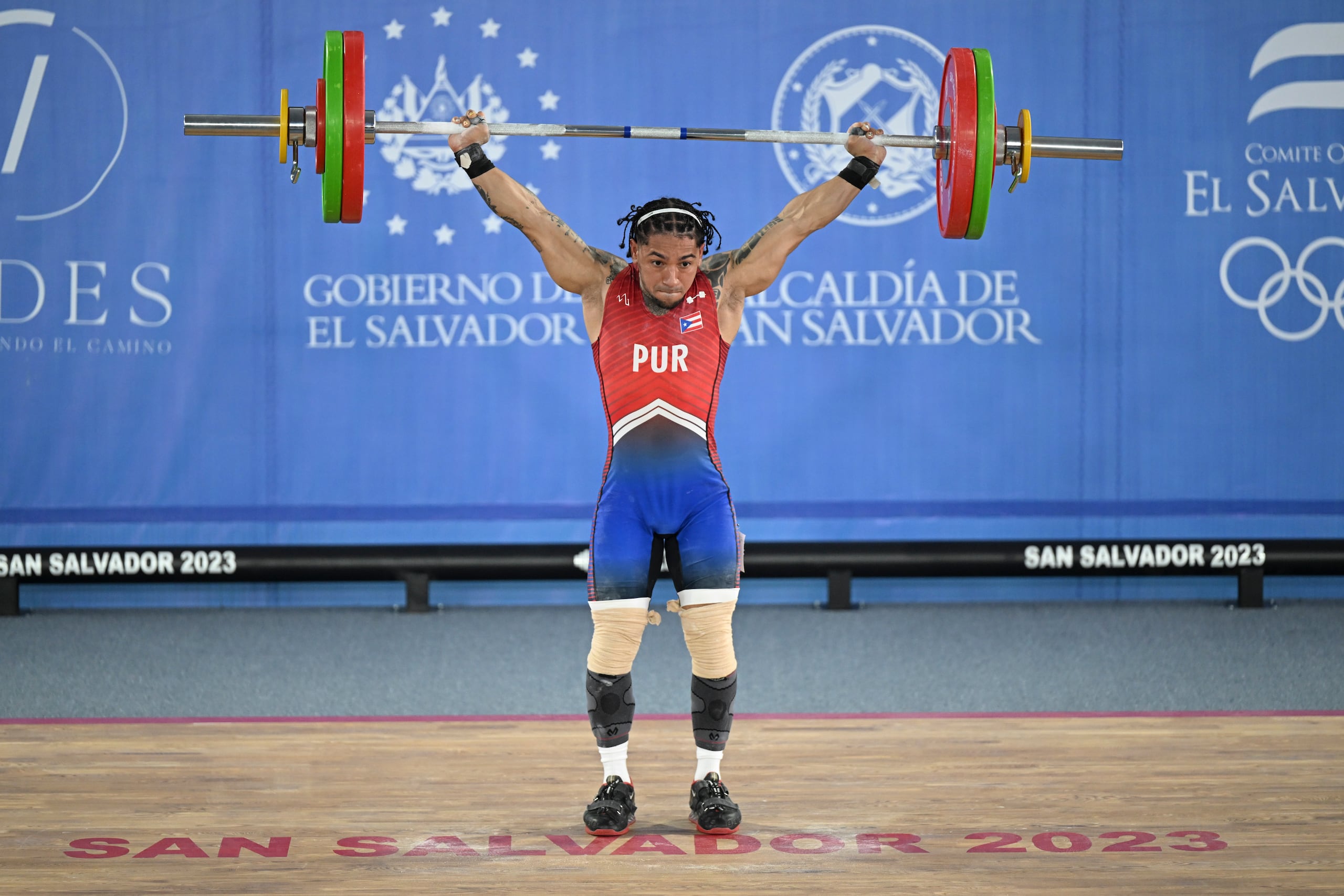 Howard Roche Cintrón sostiene las pesas durante su participación en la categoría de los 50 kilos.