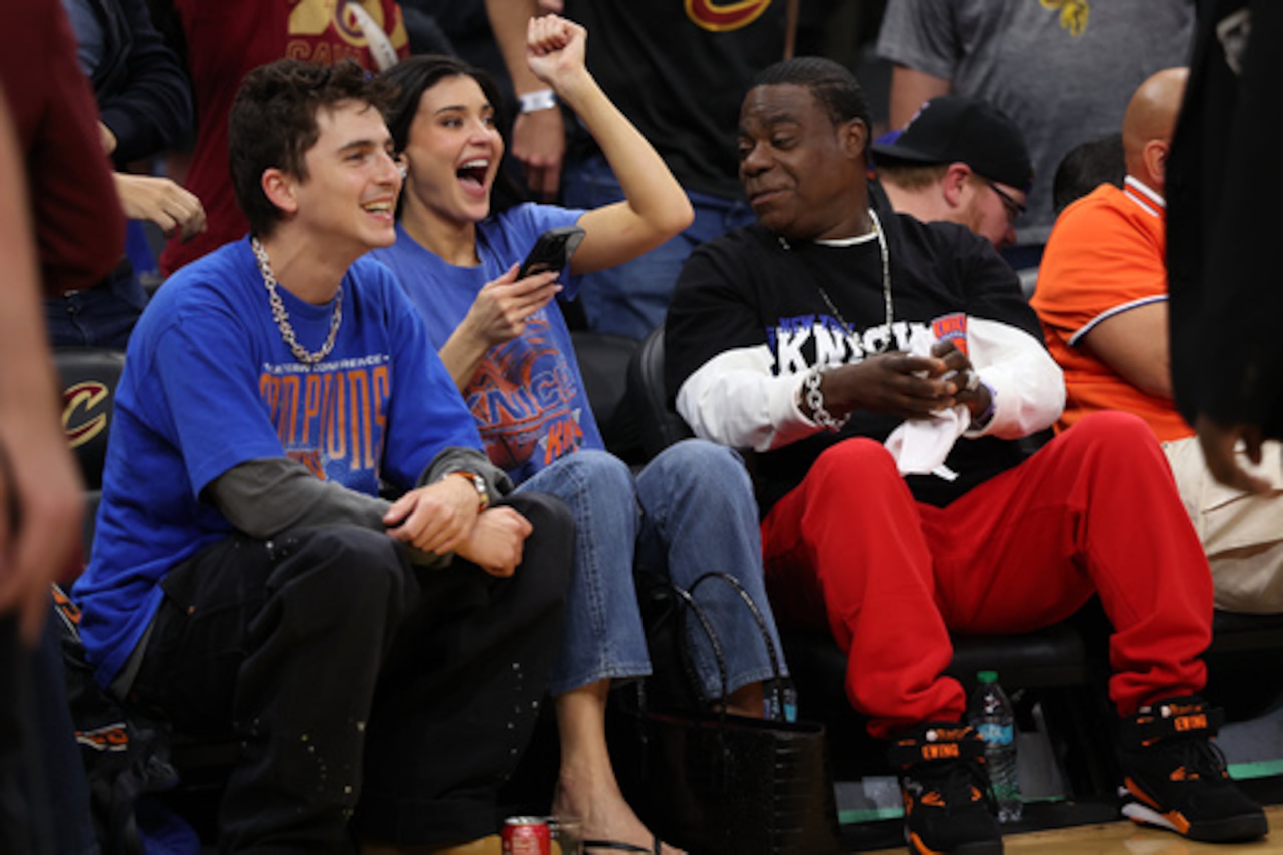 Timothée Chalamet (izquierda), Kylie Jenner (centro) y Tracy Morgan observan la segunda parte del cuarto partido de la final de la Conferencia Este de baloncesto de la NBA entre los New York Knicks y los Cleveland Cavaliers en Cleveland, el lunes 25 de mayo de 2026. (AP Photo/Tim Phillis)