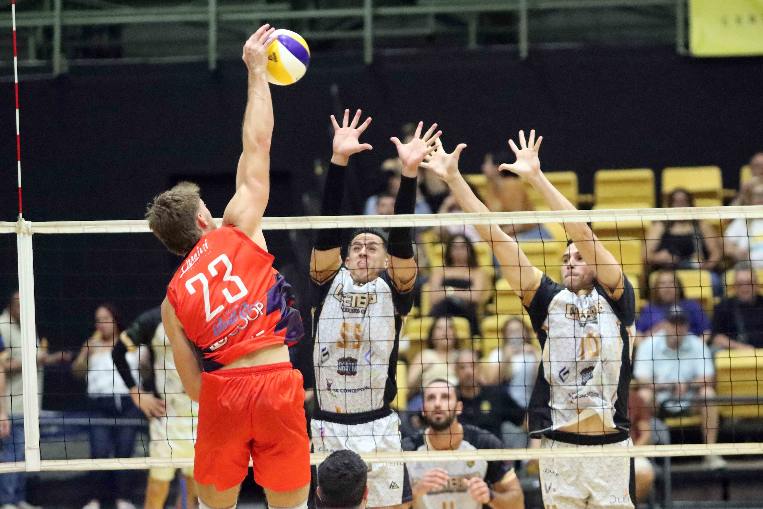 Kevin Rodriguez e Ivan Fernandez, ambos de los Cafeteros de Yauco, intentan bloquear un ataque de Cameron Milligan, de los Gigantes de Carolina.