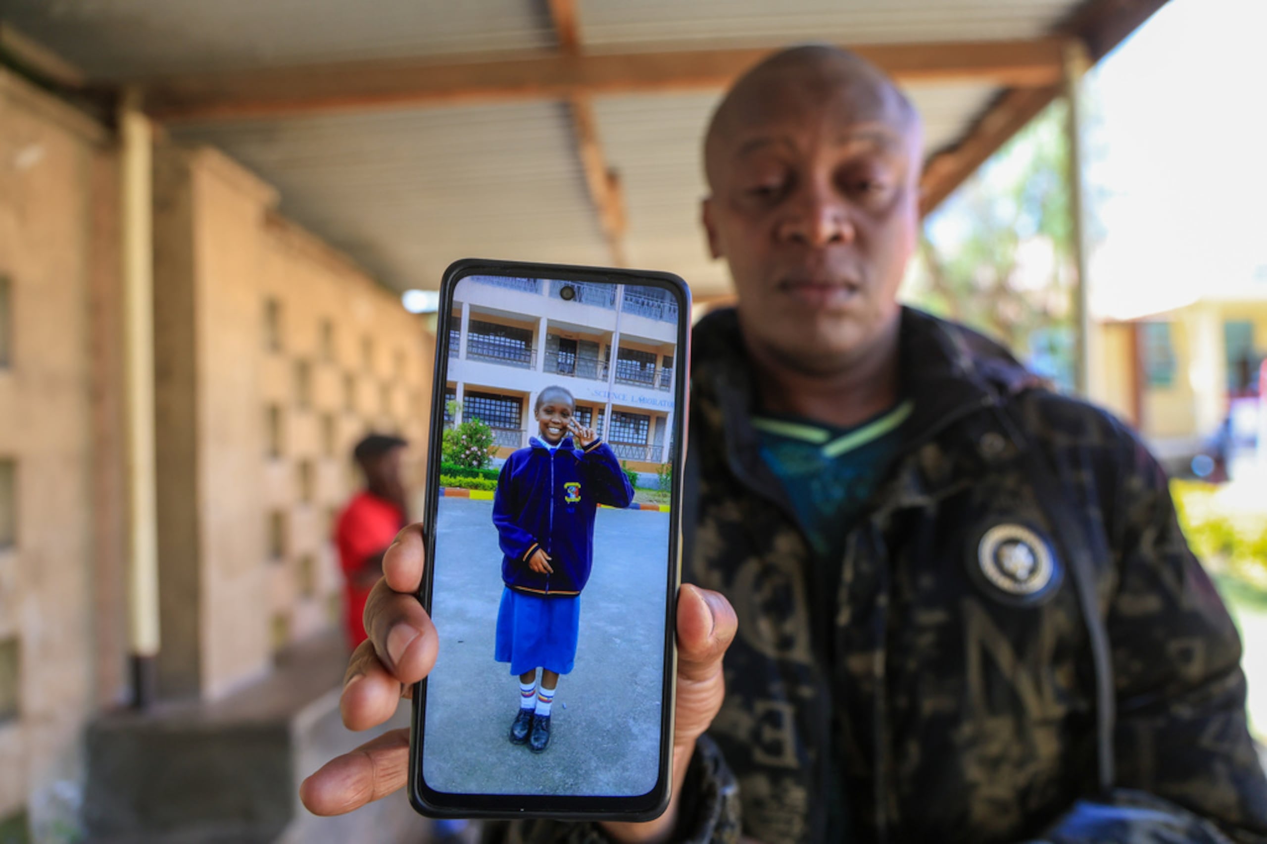 John Muiruri, padre de Nicole Muiruri, quien murió en el incendio, muestra una foto de su hija mientras espera la identificación del cuerpo y las pruebas de ADN en la funeraria de Naivasha, en la ciudad de Naivasha, región del Valle del Rift, Kenia, el 29 de mayo de 2026.