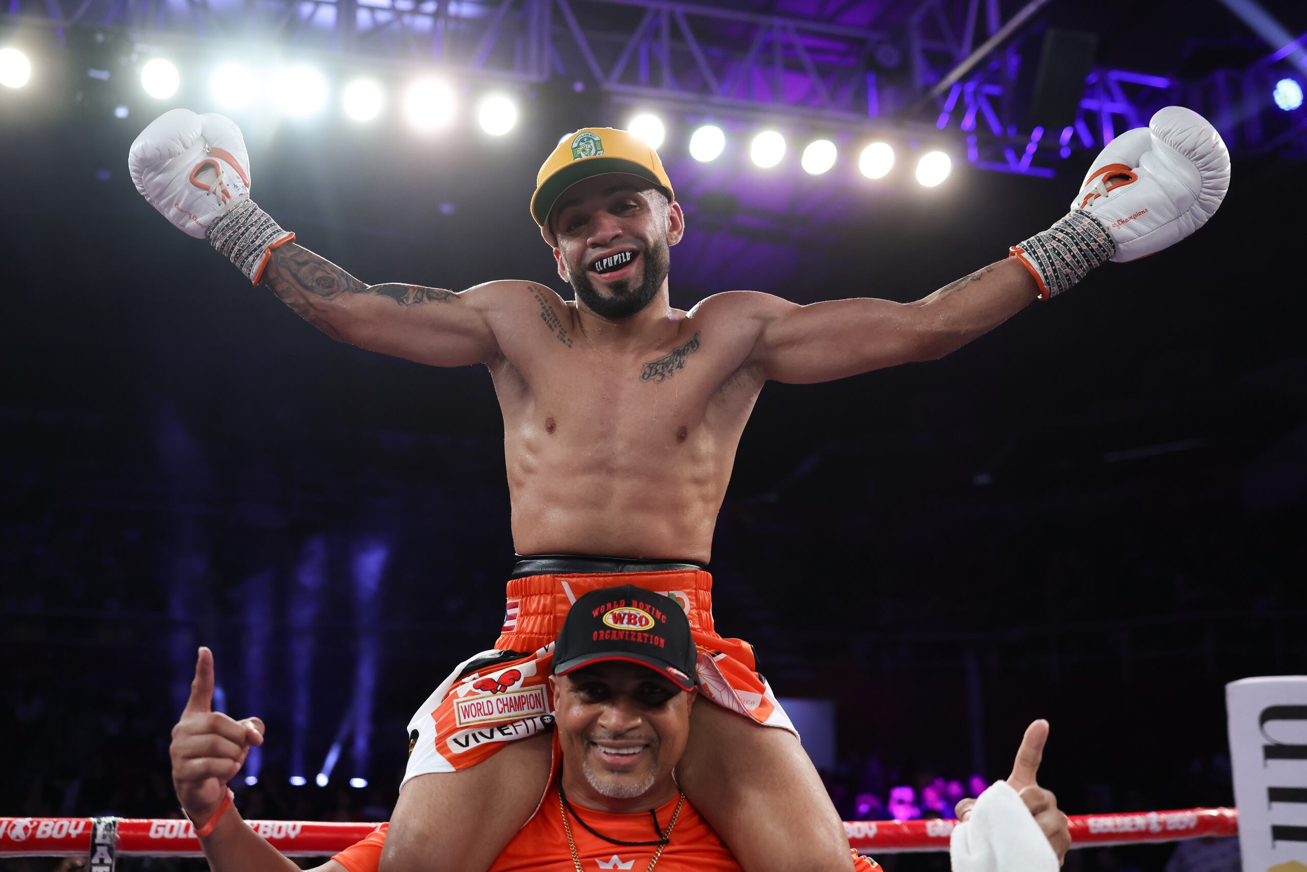 Oscar Collazo celebrando ul triunfo en los hombros de su entrenador, Juan de León.
