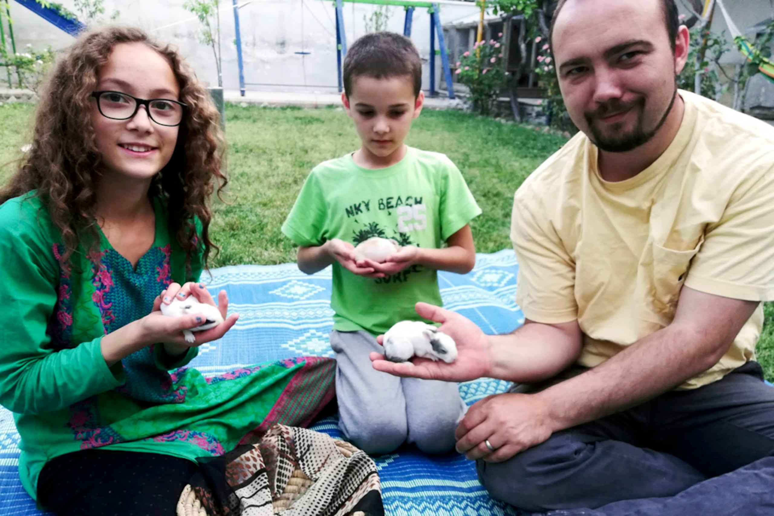 Esta foto familiar muestra a Ryan Corbett sosteniendo conejos con su hija Miriam y su hijo Caleb en Kabul, Afganistán, en 2020. Corbett fue secuestrado por los talibanes en agosto de 2022 durante un viaje de negocios.