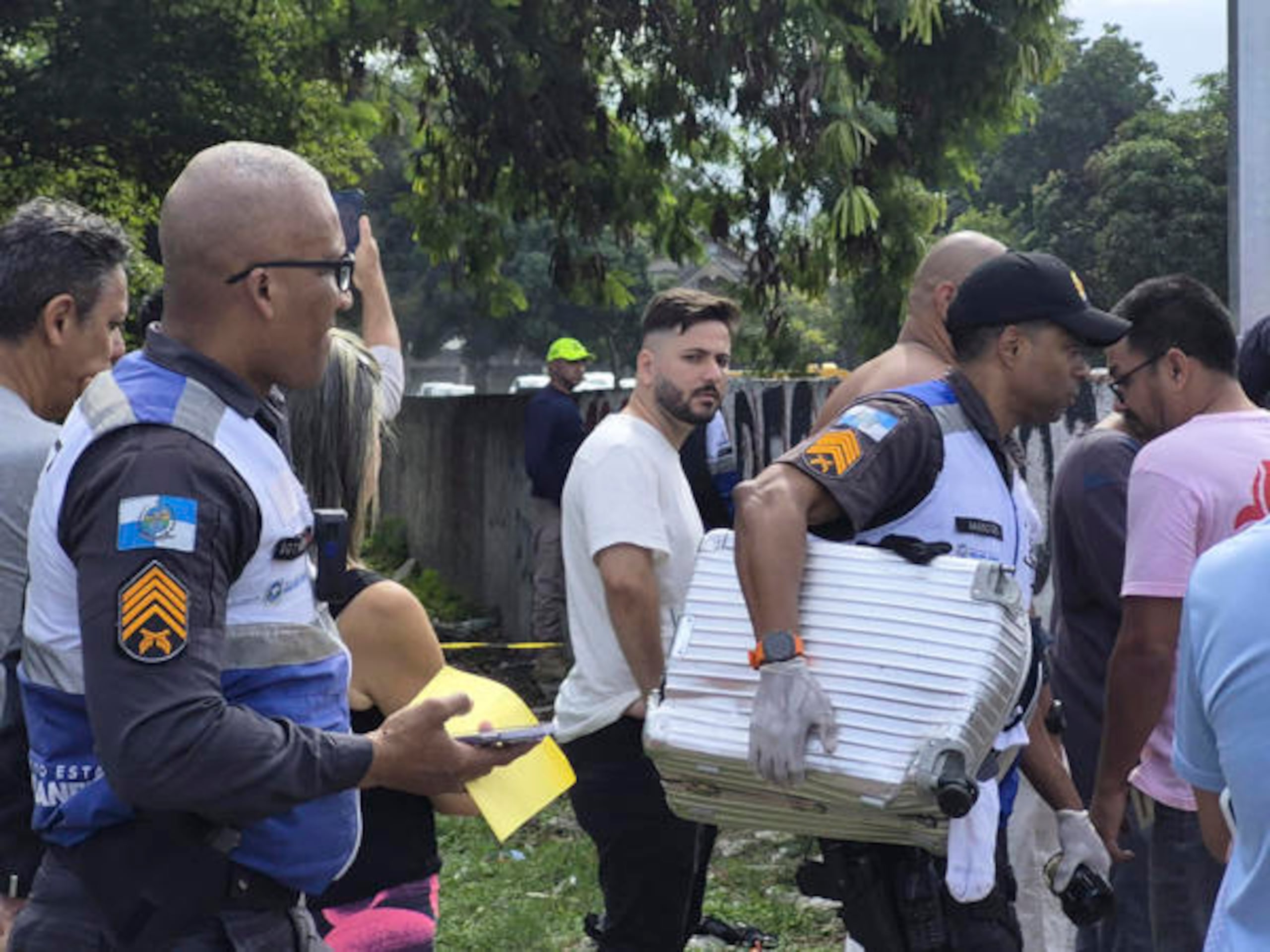 Fotografía cedida este domingo por Roberta Durço que muestra a un policía militar transportando una maleta recuperada en el lugar donde ocurrió el accidente de dos helicópteros