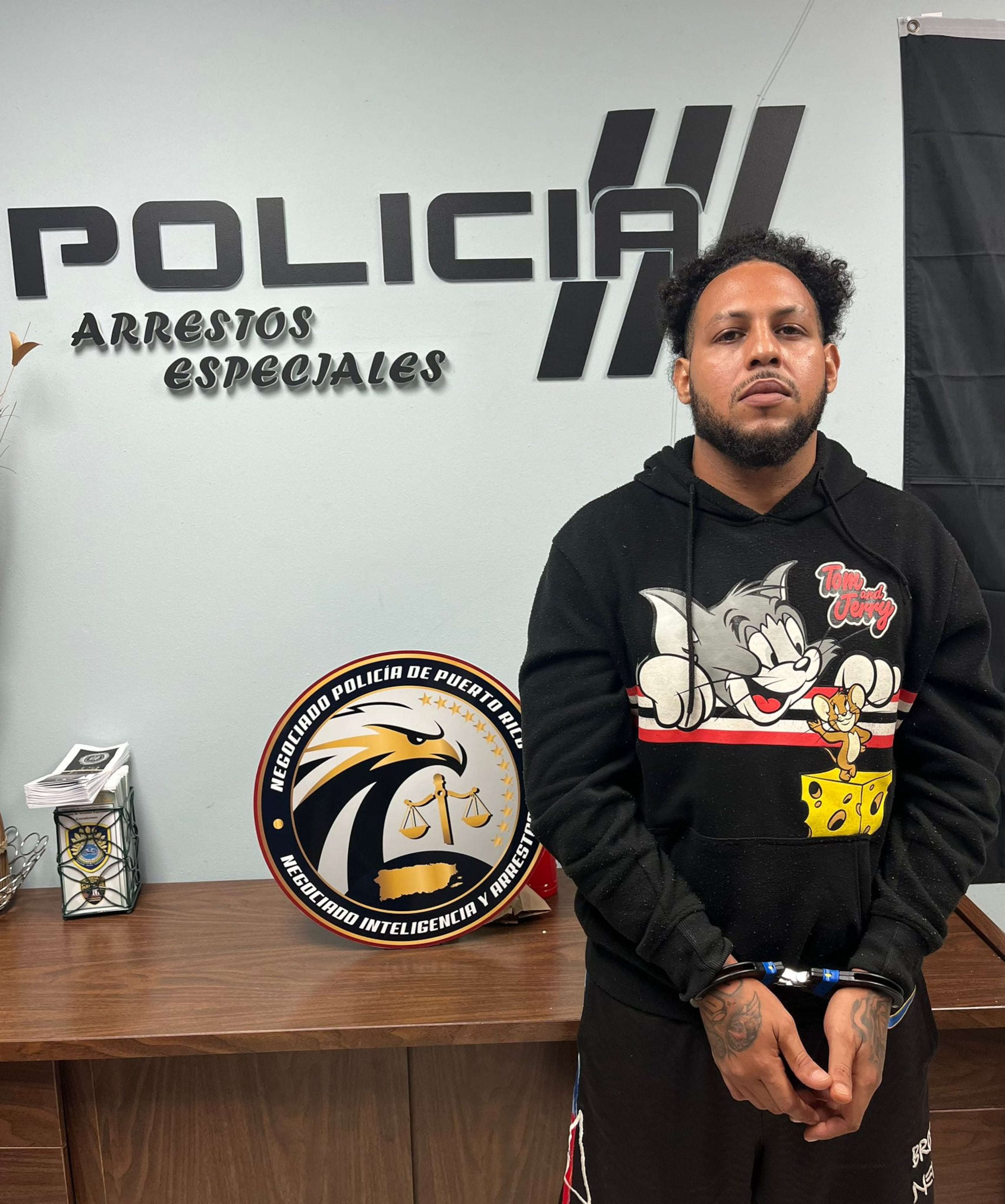 El fugitivo, Jonathan E. Rodríguez Acosta, de 31 años, alias John Pri, arrestado en una residencia del sector Valle Seco, en el barrio Río Hondo, en Mayagüez.
El detenido figuraba en la primera posición de la lista de los “10 Más Buscados” del área de Mayagüez.
Contra Rodríguez Acosta, existía una orden de arresto por violación al art. 6.09 (Portación, Posesión o Uso Ilegal de Armas Largas Semiautomáticas, Automáticas o Escopeta de Cañón Cortado) y 6.22 (Fabricación, Distribución, Posesión y Uso de Municiones; Importación de Municiones) de la Ley de Armas de Puerto Rico y por infracción a la Ley de Sustancias Controladas de Puerto Rico, expedida por la jueza María del Pilar Vázquez, del Tribunal de Mayagüez, con una fianza $250,000.