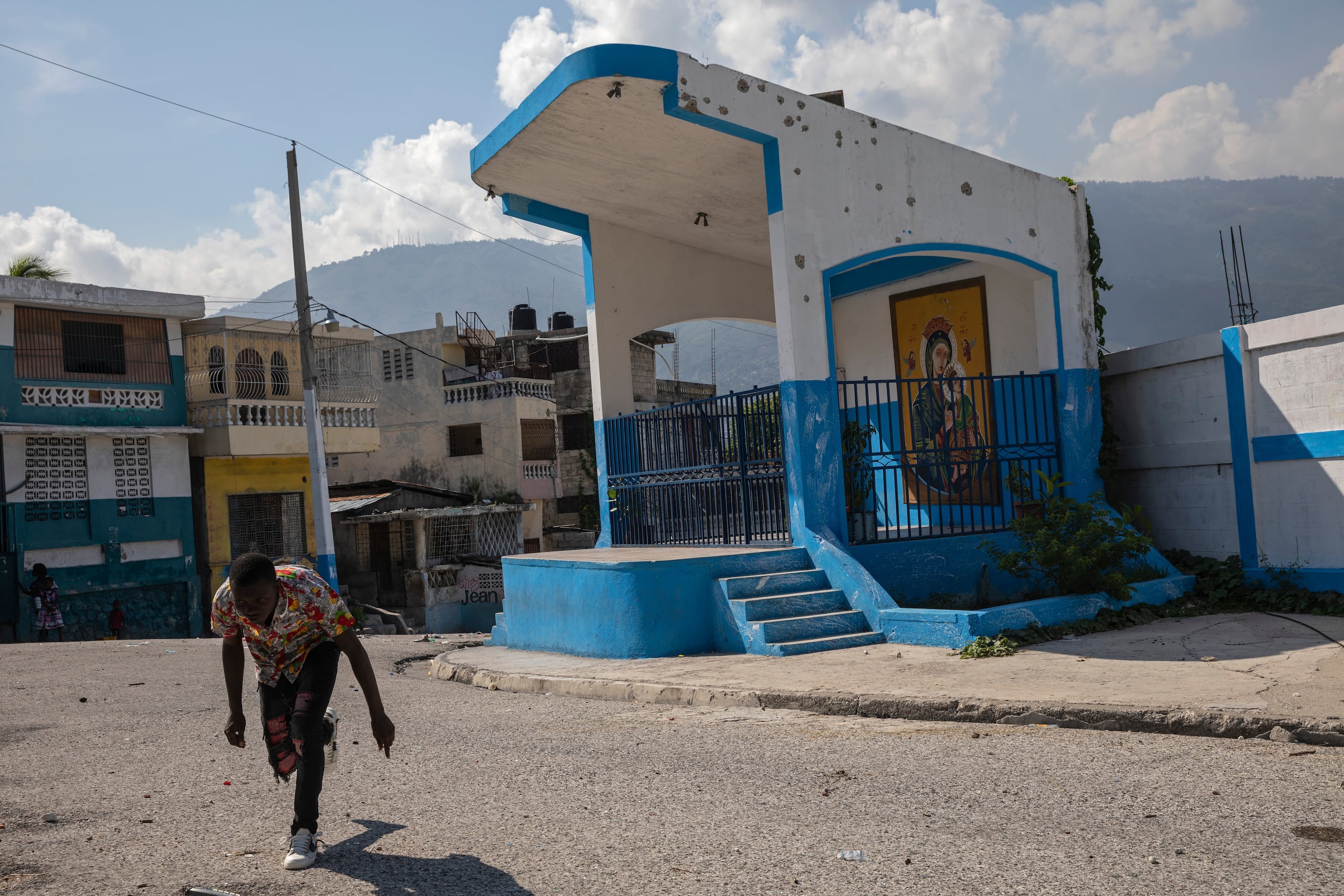 Un hombre al cruzar una calle con barricadas en el vecindario Bel Air de Puerto Príncipe, Haití, el 25 de septiembre del 2021. (AP foto/Rodrigo Abd)