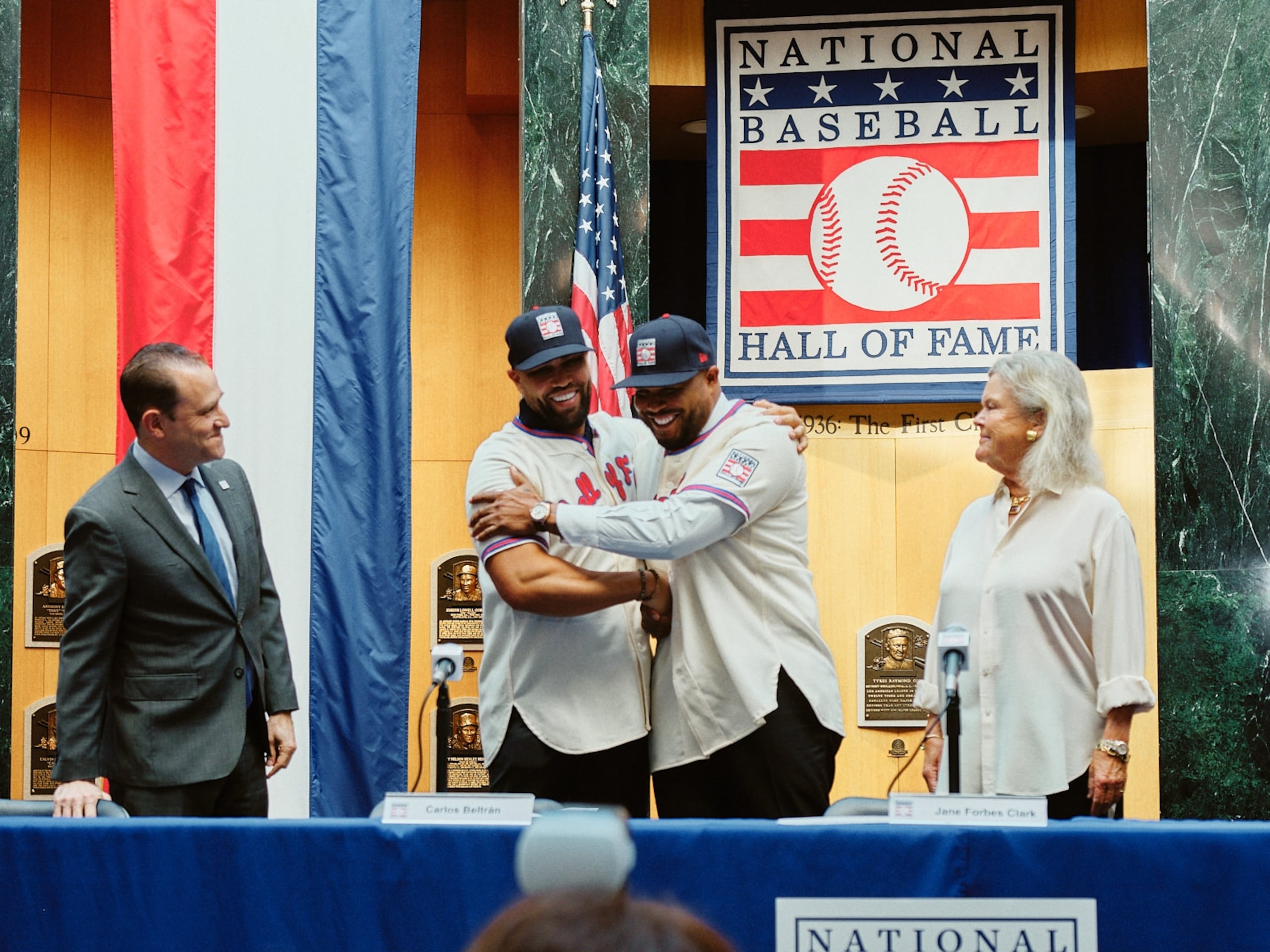 Carlos Beltrán y Andruw Jones se abrazan instantes después de vestir por primera vez con la camisa y gorra del equipo de exaltados al Salón de la Fama. (Carlos Pérez)