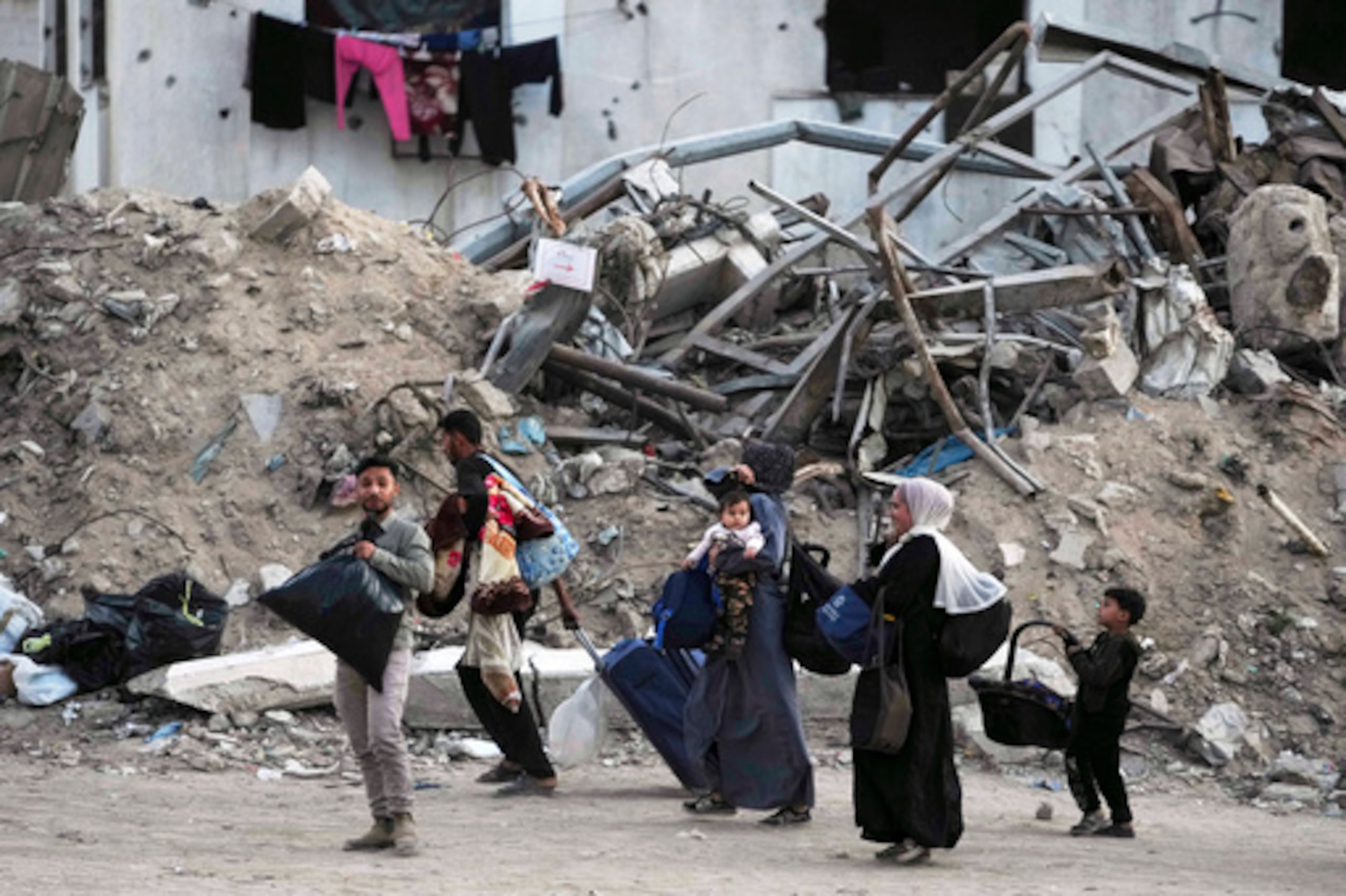 Familias palestinas evacuadas de Rimal, Ciudad de Gaza, tras advertencia del ejército israelí. La imagen muestra la devastación en la zona.