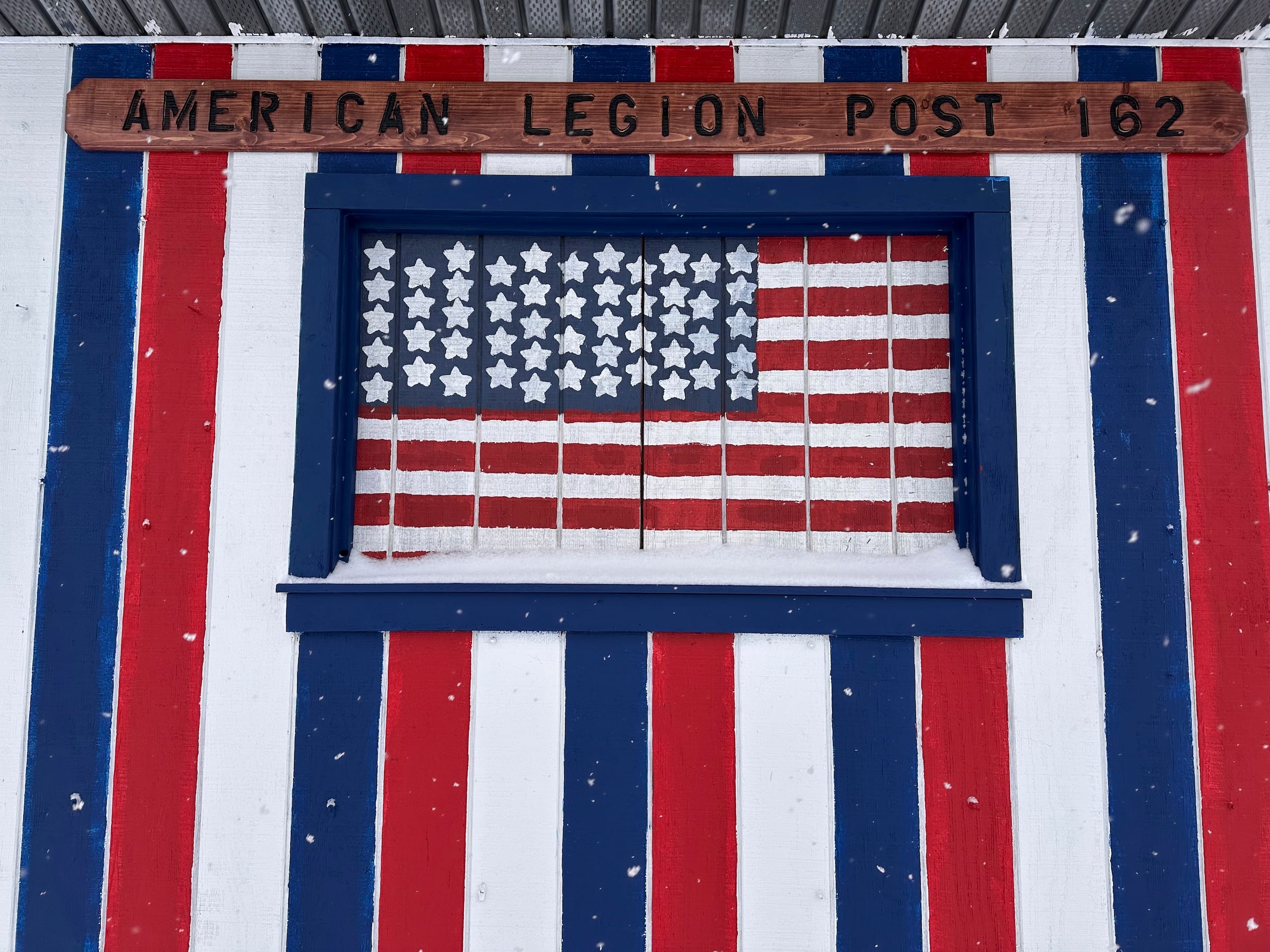 More snow falls near the American Legion Post in Lowville, N.Y., Sunday, Jan. 5, 2025. (AP Photo/Cara Anna)