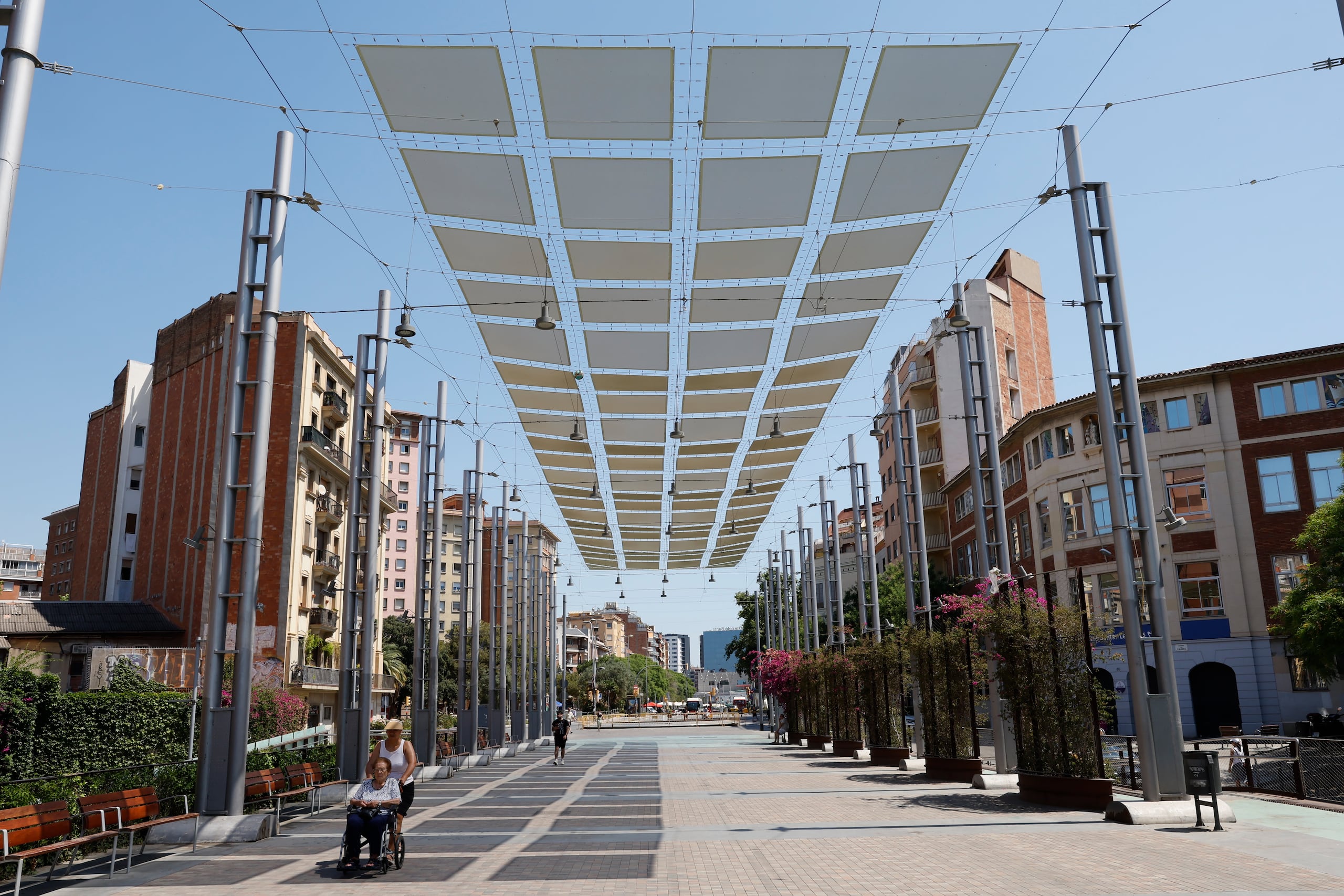 Fotografía de archivo, tomada el pasado 26 de junio, en la que se captó a un grupo de personas al transitar bajo la protección de un umbráculo en la Rambla de Sants, en Barcelona (España) . EFE/Toni Albir