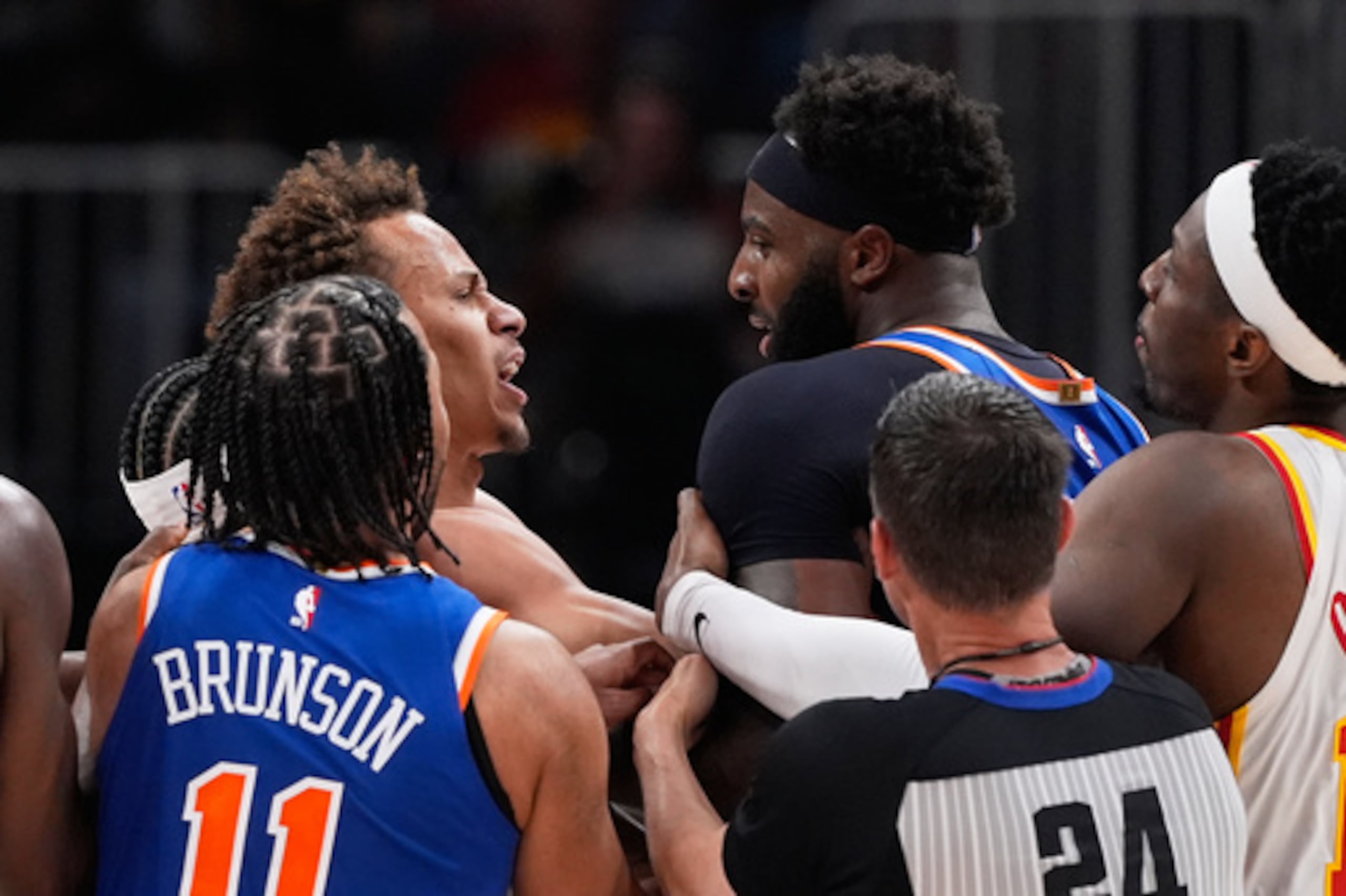 El pívot de los New York Knicks Mitchell Robinson (23) y el escolta de los Atlanta Hawks Dyson Daniels (5) pelean en la primera mitad del sexto partido de la primera ronda de los playoffs de baloncesto de la NBA, el jueves 30 de abril de 2026, en Atlanta. (AP Photo/Brynn Anderson)