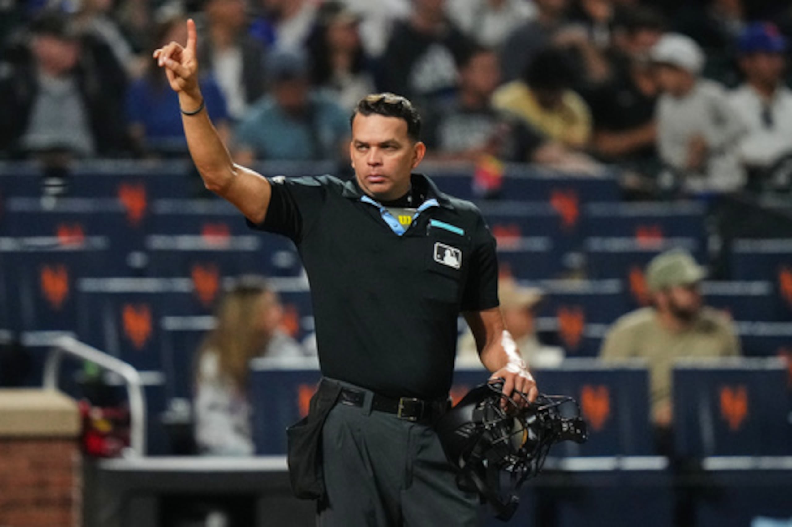 El árbitro de home Emil Jiménez hace un gesto a los jugadores durante la octava entrada de un partido de béisbol entre los Mets de Nueva York y los Rojos de Cincinnati, el martes 26 de mayo de 2026, en Nueva York. (Foto AP/Frank Franklin II)