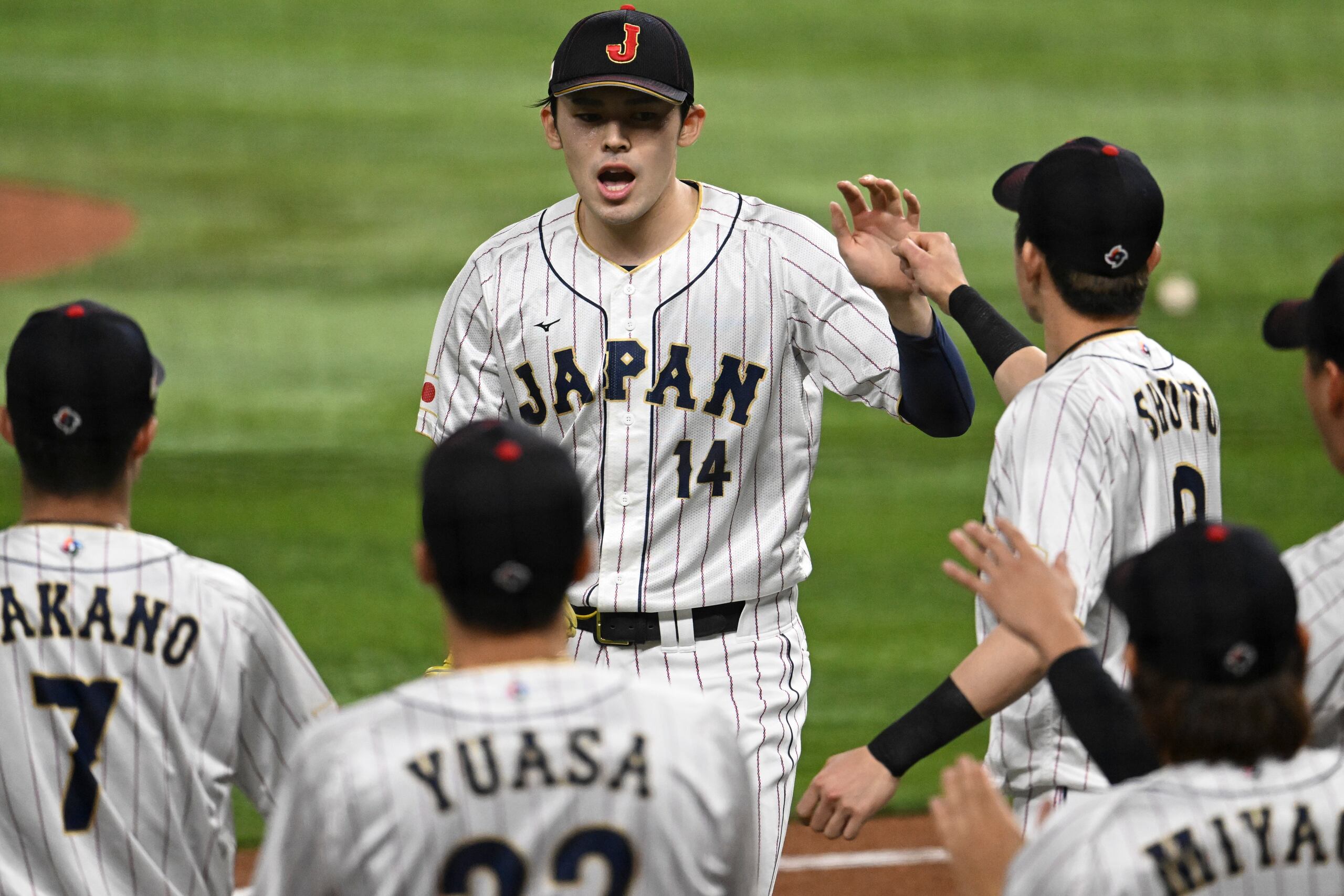 El lanzador Roki Sasaki es felicitado por sus compañeros de equipo en el Clásico Mundial de Béisbol 2023.