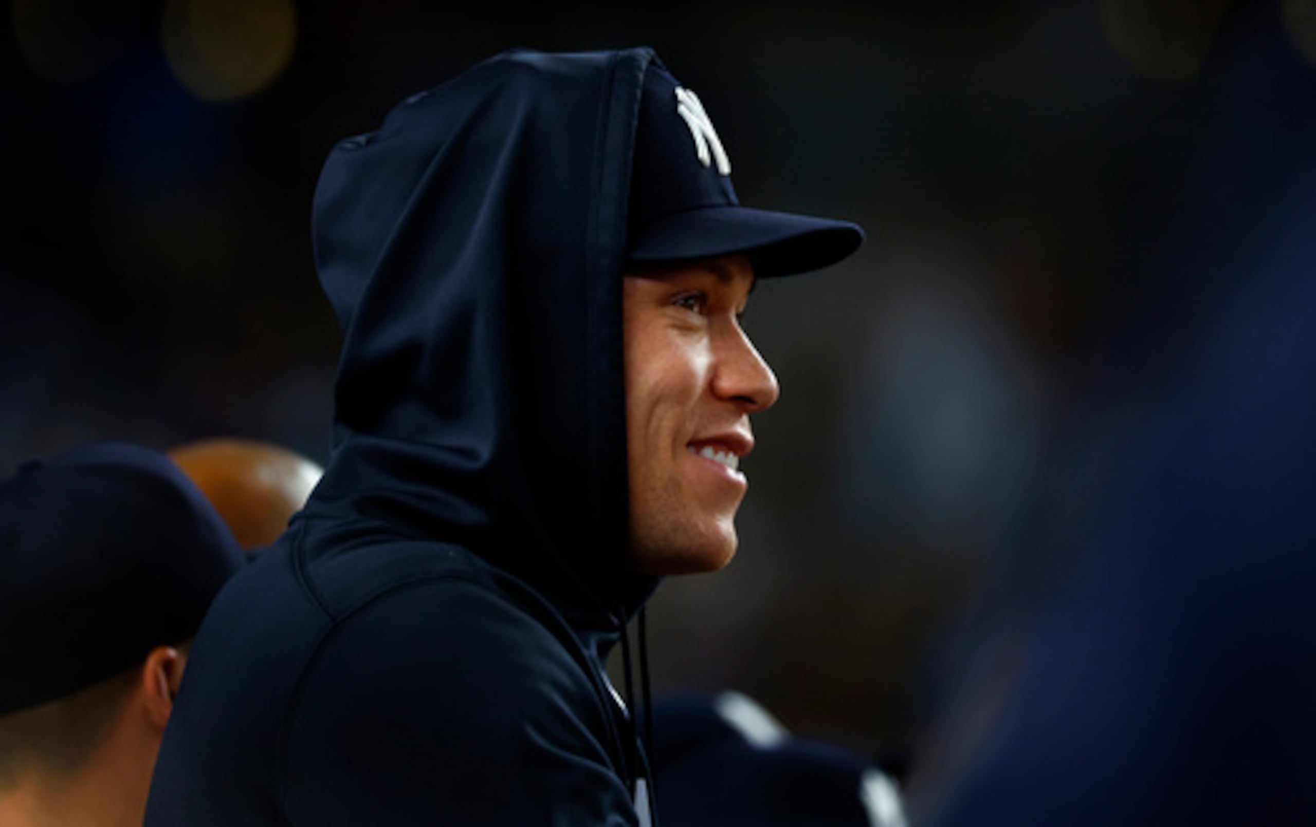 Aaron Judge, de los Yankees de Nueva York, sonríe en el banquillo durante la octava entrada de un partido de béisbol contra los Reds de Cincinnati.
