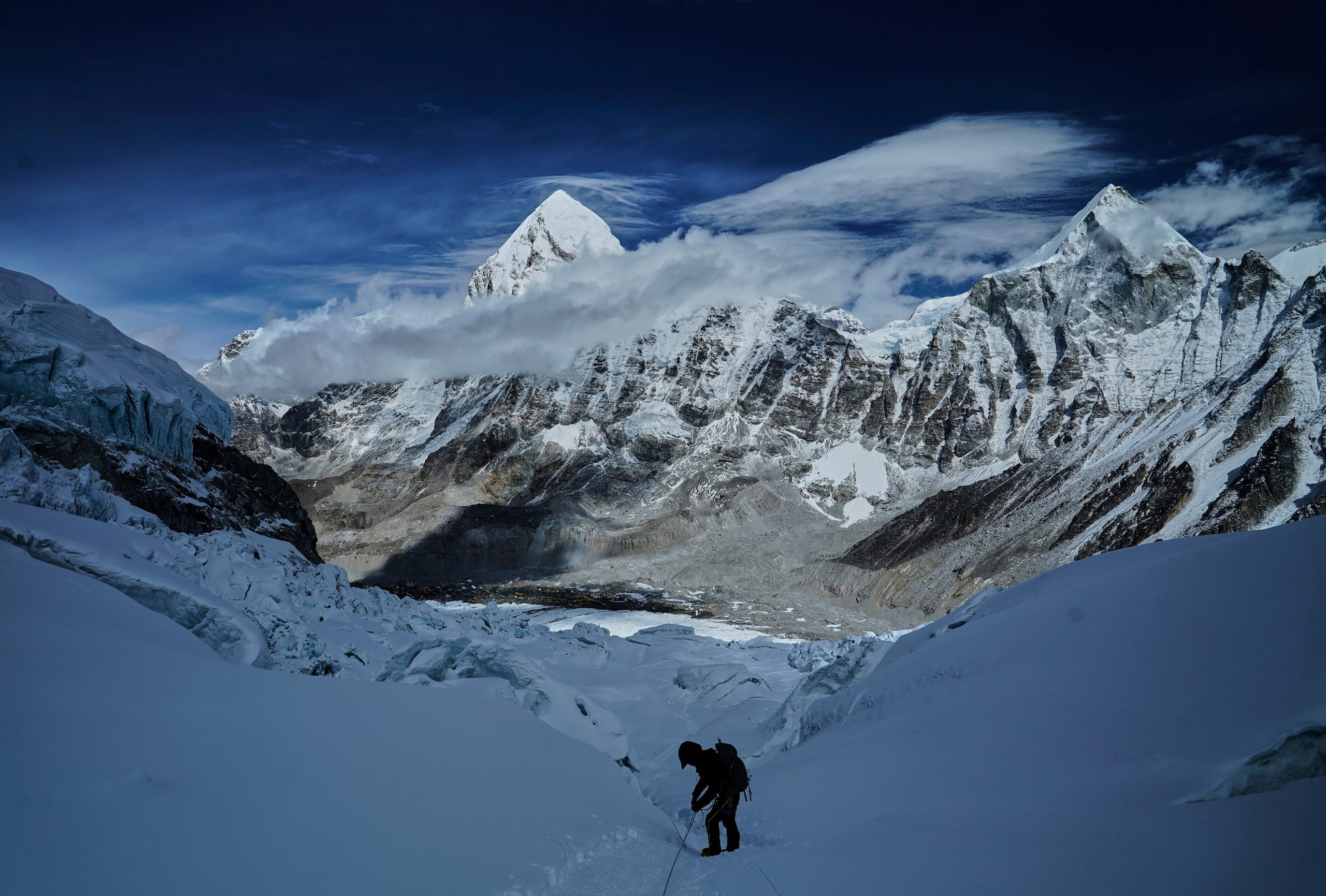 El monte Pumori, al centro en el fondo de la foto, destaca en el panorama mientras un alpinista toma precaución para descender por el Khumbu Icefall hacia la base del campamento de escalada en Nepal, en mayo de 2025.