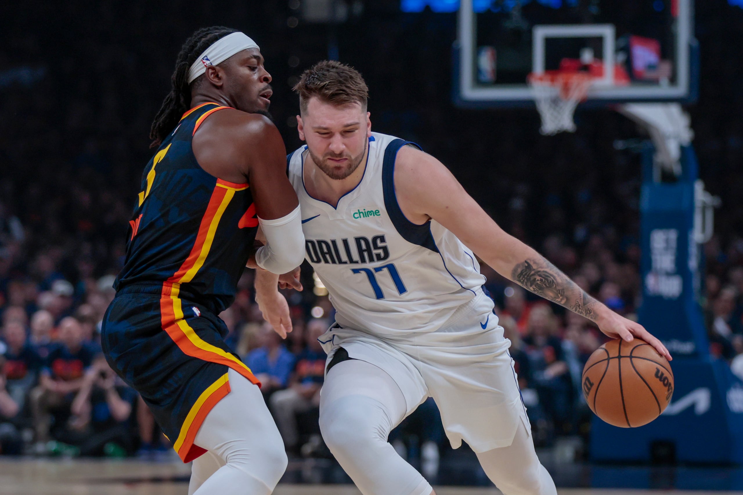 El base de los Mavericks de Dallas Luka Doncic avanza con el balón hacia la canasta superando al base del Thunder de Oklahoma City Luguentz Dort en el juego 5 de las semifinales de la Conferencia Oeste el miércoles 15 de mayo del 2024. (AP Foto/Nate Billings)
