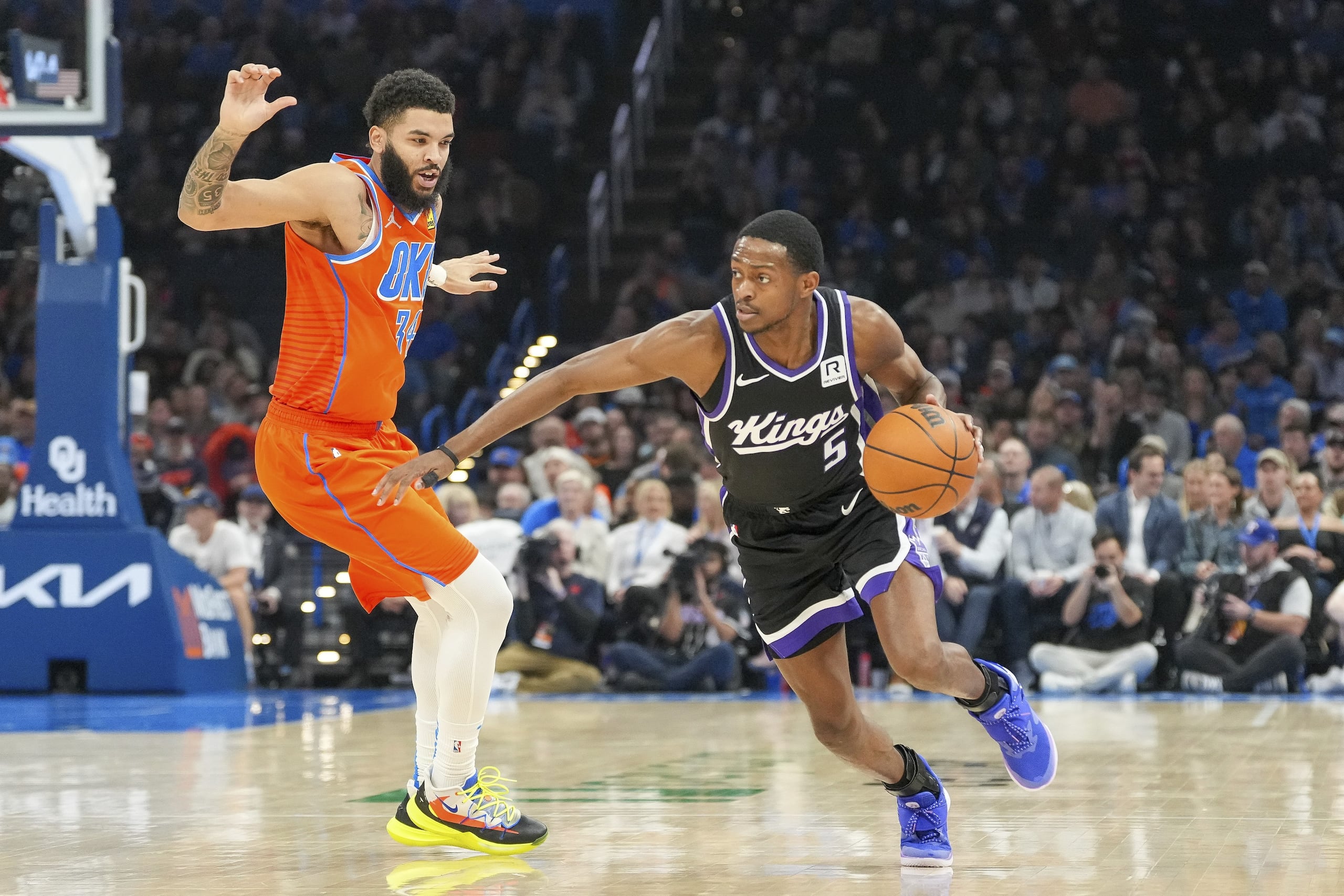 De'Aaron Fox, derecha, de los Kings de Sacramento, avanza para superar a Kenrich Williams, del Thunder de Oklahoma City, durante la primera mitad del juego de baloncesto de la NBA, el sábado 1 de febrero de 2025, en Oklahoma City.