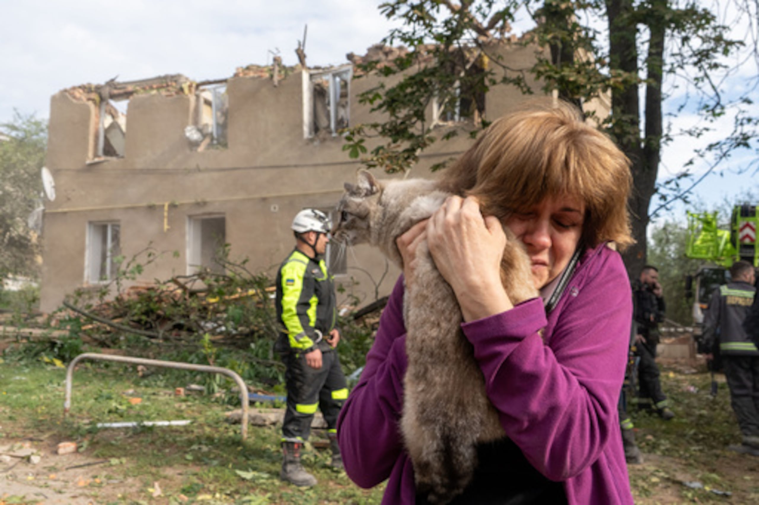 Una mujer sostiene a su gato tras haberlo encontrado durante las labores de búsqueda y rescate en el edificio residencial dañado a raíz del ataque con misiles de Rusia en Járkov, Ucrania, el sábado 20 de junio de 2026. (Foto AP/Andrii Marienko)