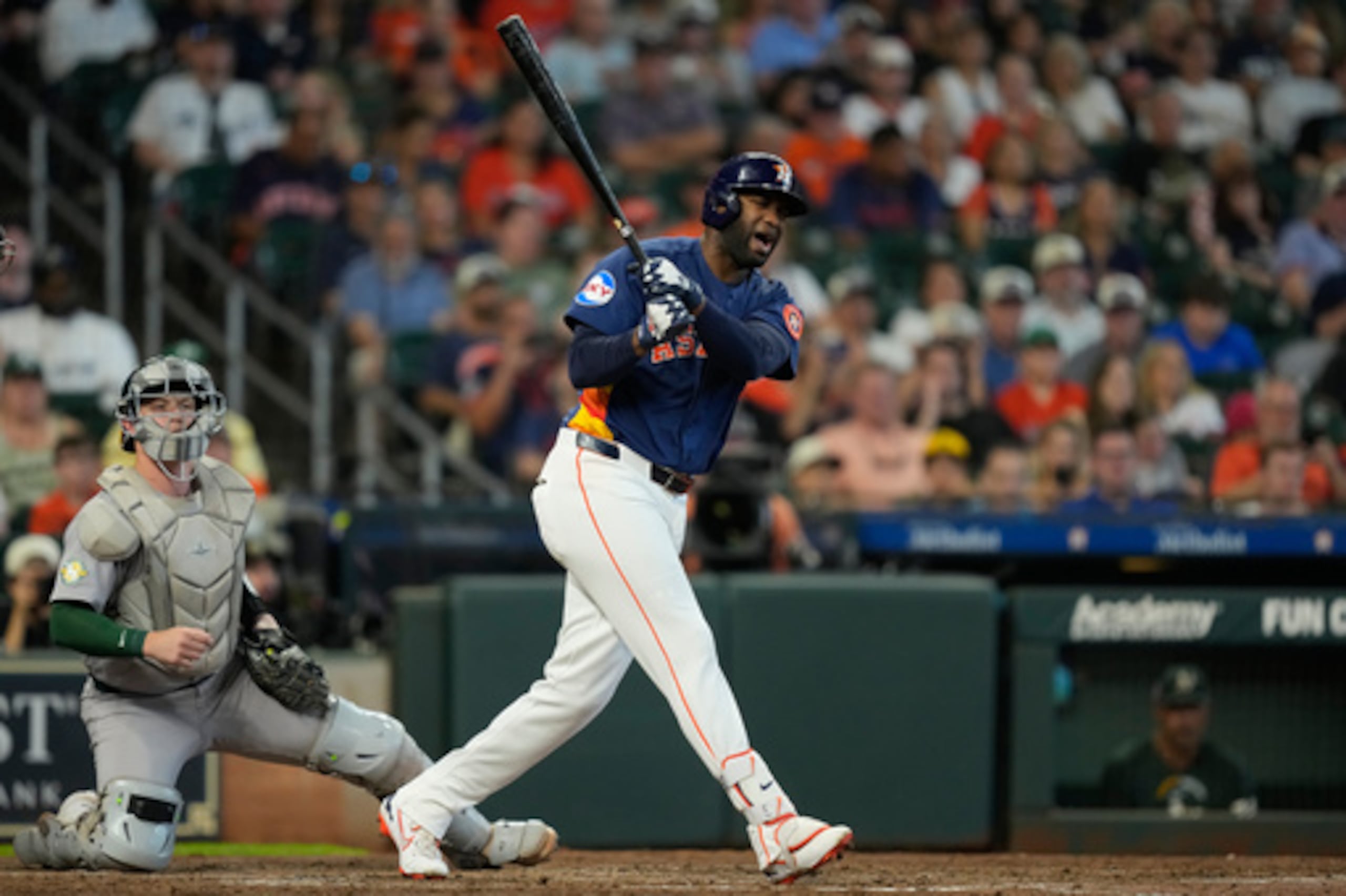 Yordan Álvarez, de los Astros de Houston (a la derecha), reacciona tras recibir un lanzamiento en el pie frente al receptor de los Athletics, Brian Serven, durante la cuarta entrada de un partido de béisbol celebrado el domingo 23 de agosto de 2026 en Houston. (Foto AP/David J. Phillip)