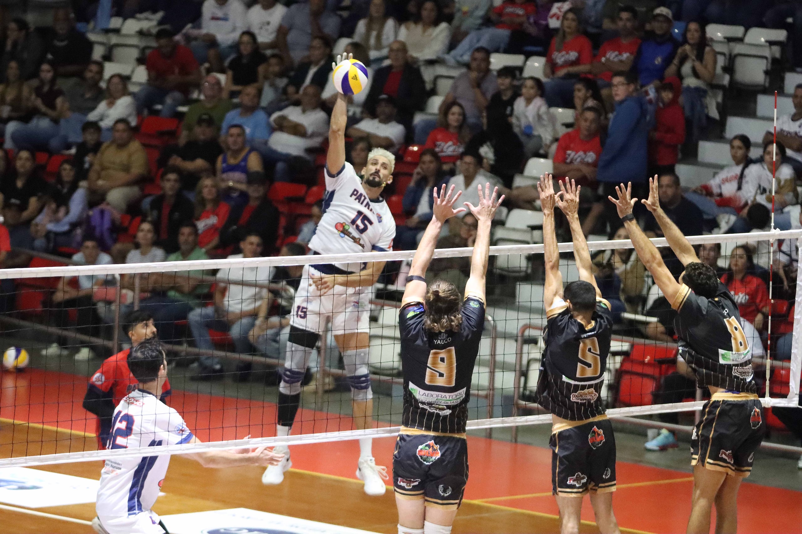 Jair Santiago, de los Patriotas de Lares, ataca contra el triple bloqueo de los Cafeteros de Yauco.