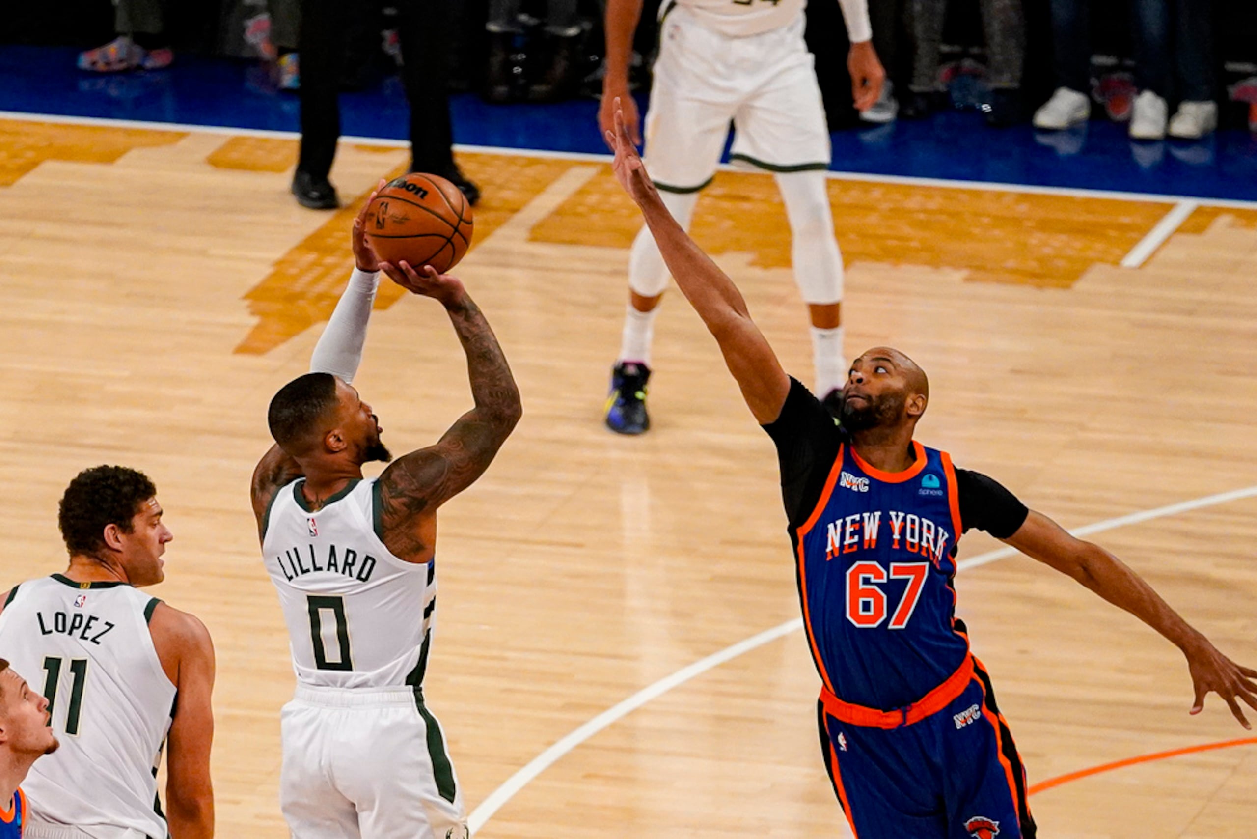 Damian Lillard tira por encima de la defensa de Taj Gibson (67).