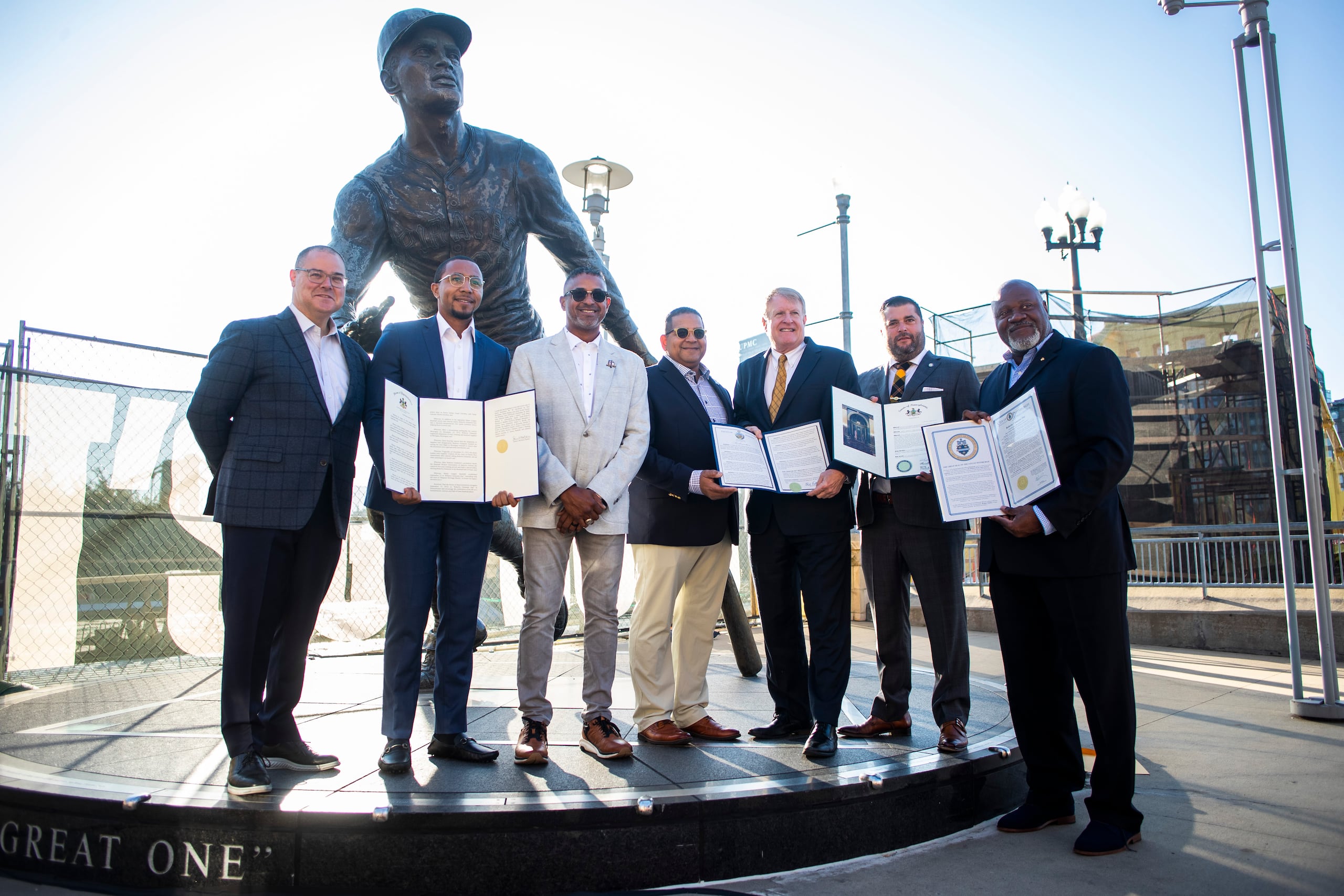 En la foto Travis Williams, presidente de los Piratas; el representante Aerion Abney; los hijos de Roberto Clemente, Roberto Jr. y Luis Roberto, Rich Fitzgerald, el representante Devlin Robinson y Jake Wheatley en nombre del alcalde Ed Gainey, posan frente a la estatua de Clemente en el PNC Park.