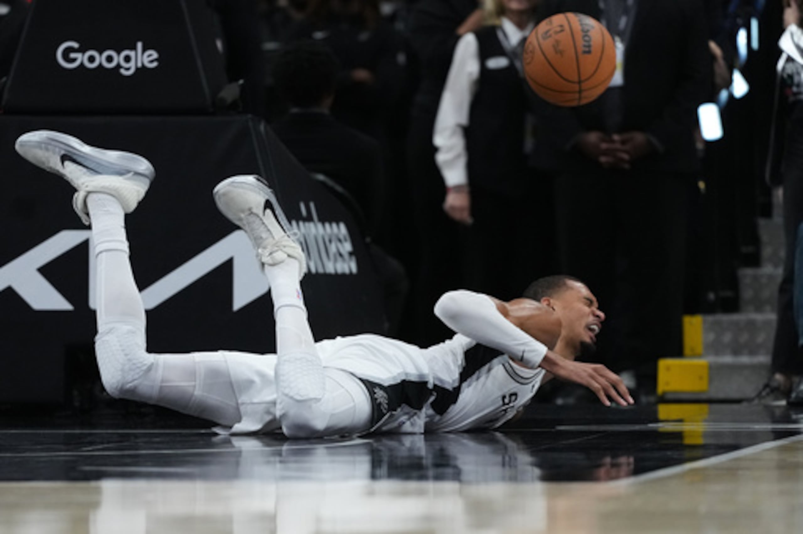 El alero de los San Antonio Spurs Victor Wembanyama (1) sufre una dura caída en la cancha durante la primera mitad del segundo partido de la primera ronda de los playoffs de baloncesto de la NBA contra los Portland Trail Blazers en San Antonio, el martes 21 de abril de 2026. (AP Photo/Eric Gay)