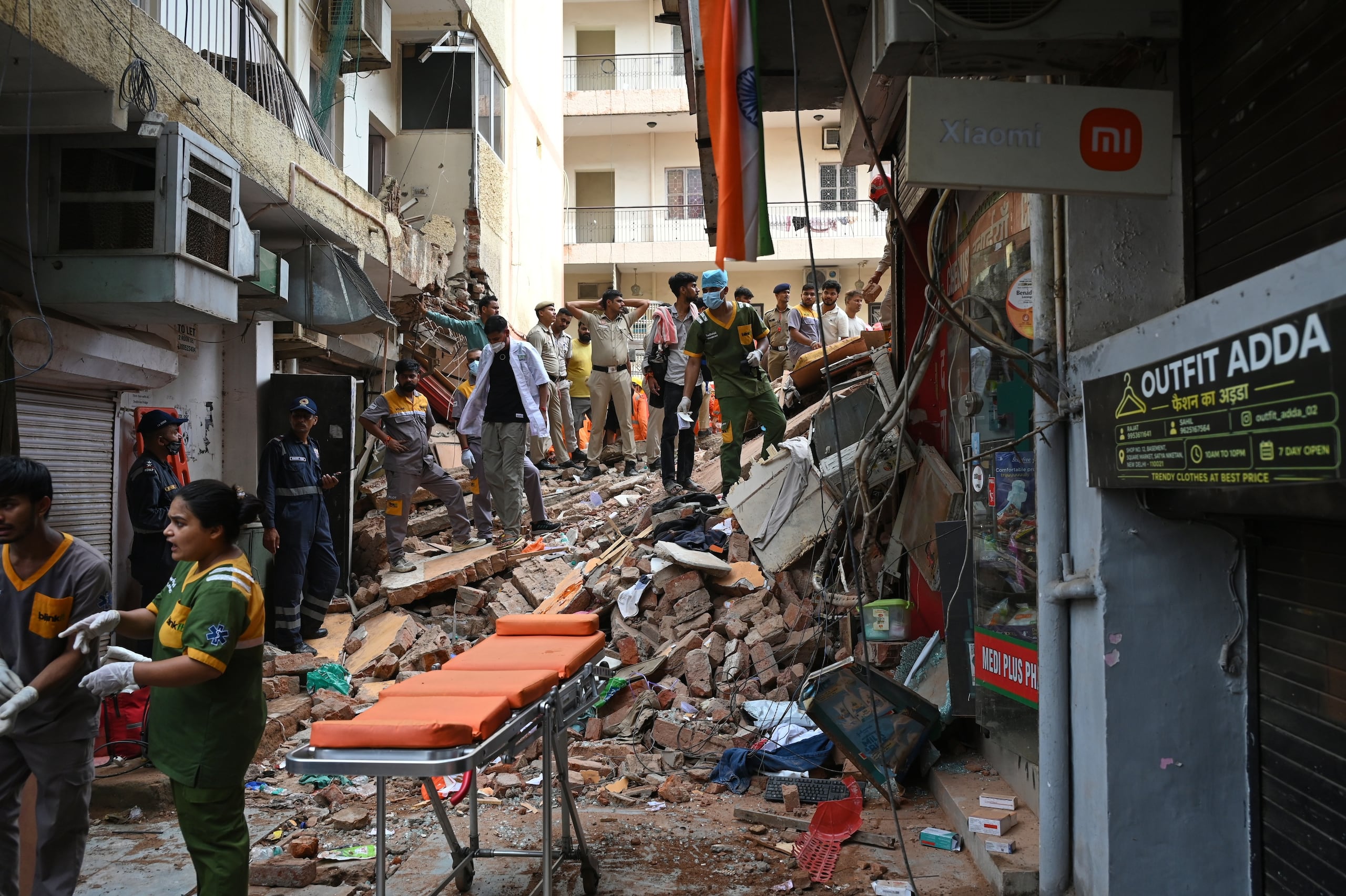 Paramédicos permanecen a la espera con una camilla cerca de un edificio que se desplomó, el domingo 6 de septiembre de 2026, en Nueva Delhi, India. (AP Foto/Vipin)