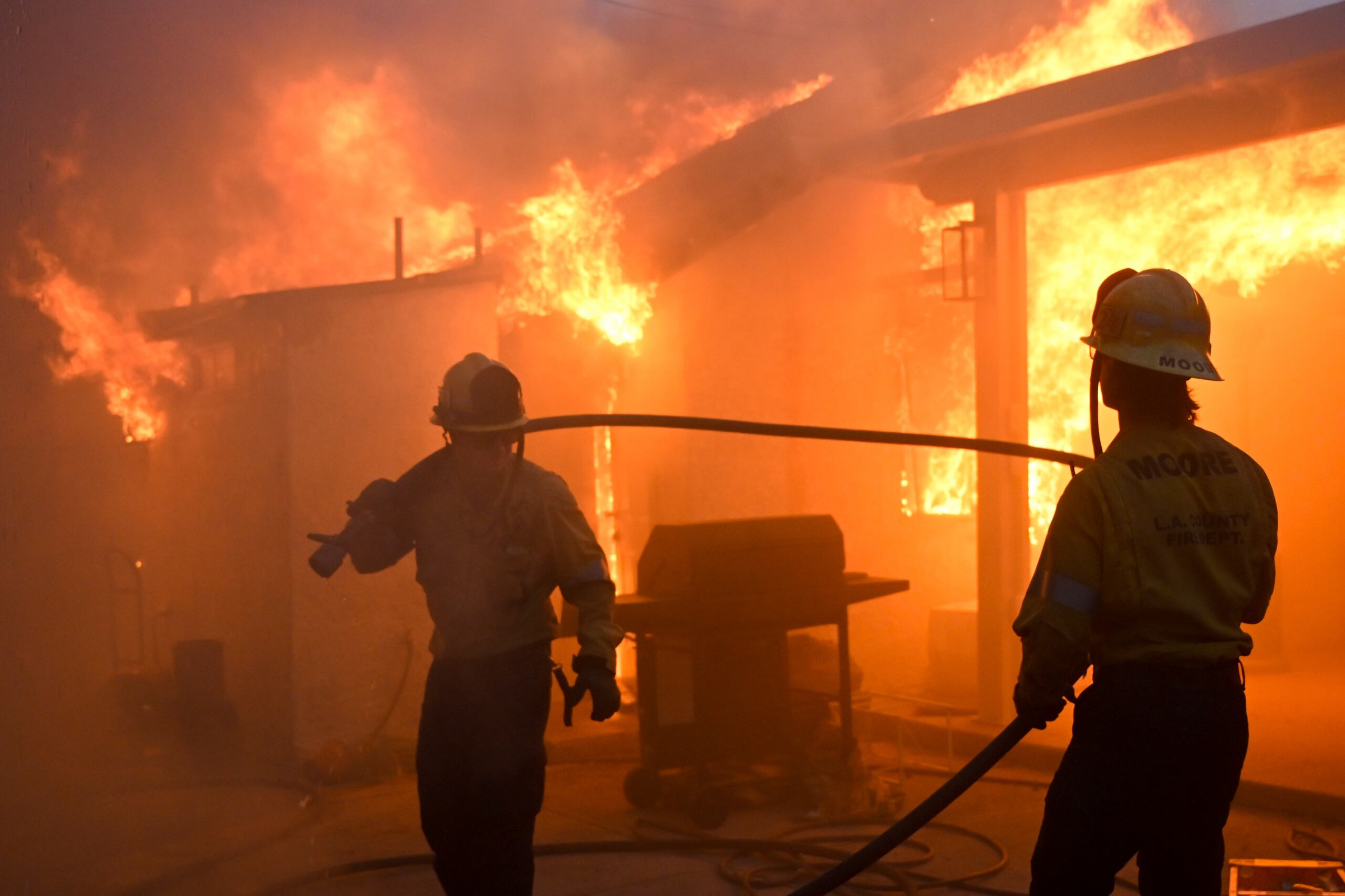 Dos bomberos luchan contra el incendio Eaton, que arrasa con varias construcciones en Altadena, California, el miércoles 8 de enero de 2025.