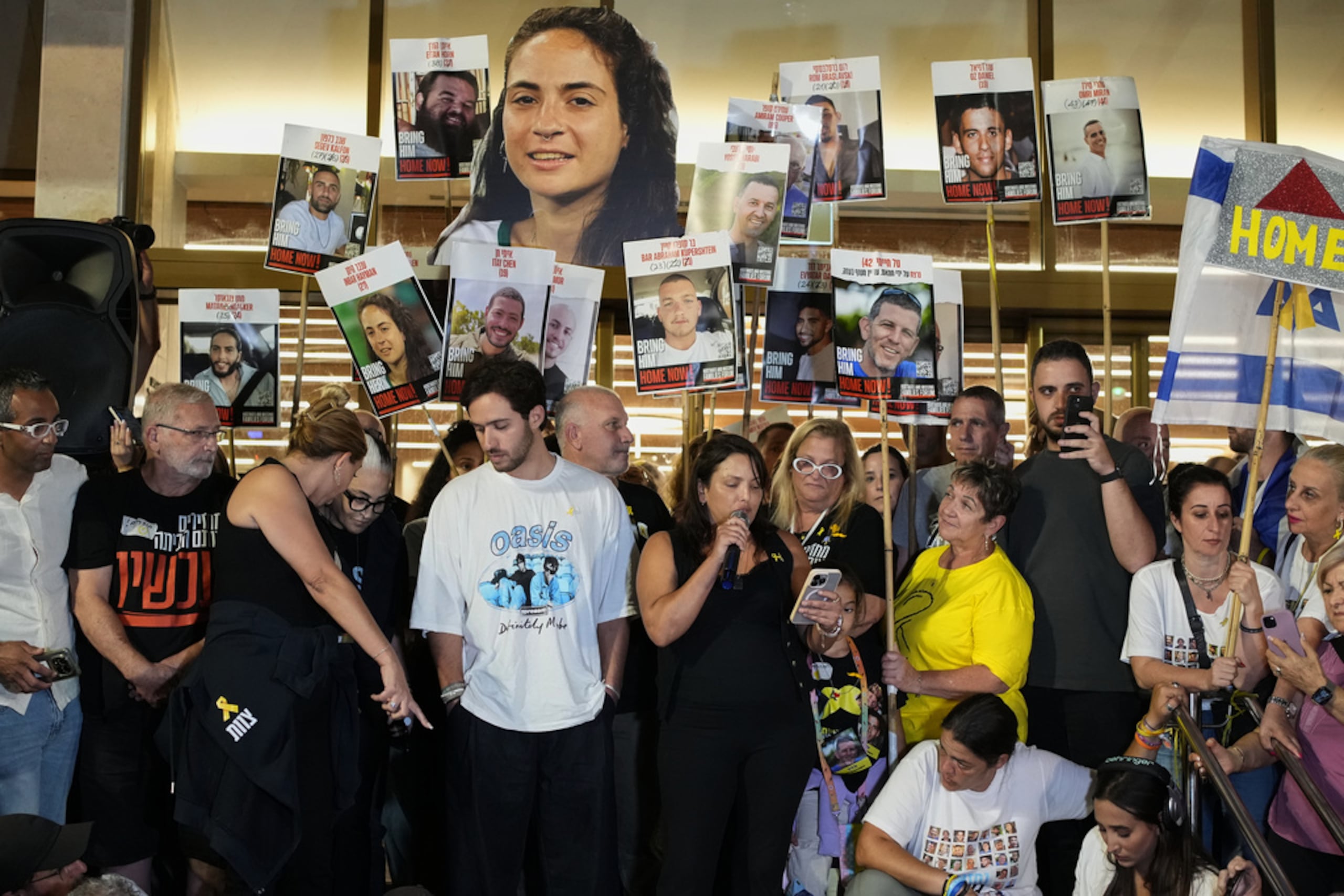 Familiares y simpatizantes de los rehenes israelíes retenidos por Hamás en la Franja de Gaza sostienen carteles con retratos de sus seres queridos durante una concentración tras el anuncio de que Israel y Hamás acordaron la primera fase de un plan de paz para pausar los combates, en una plaza conocida como Plaza de los Rehenes en Tel Aviv, Israel, el 9 de octubre de 2025.