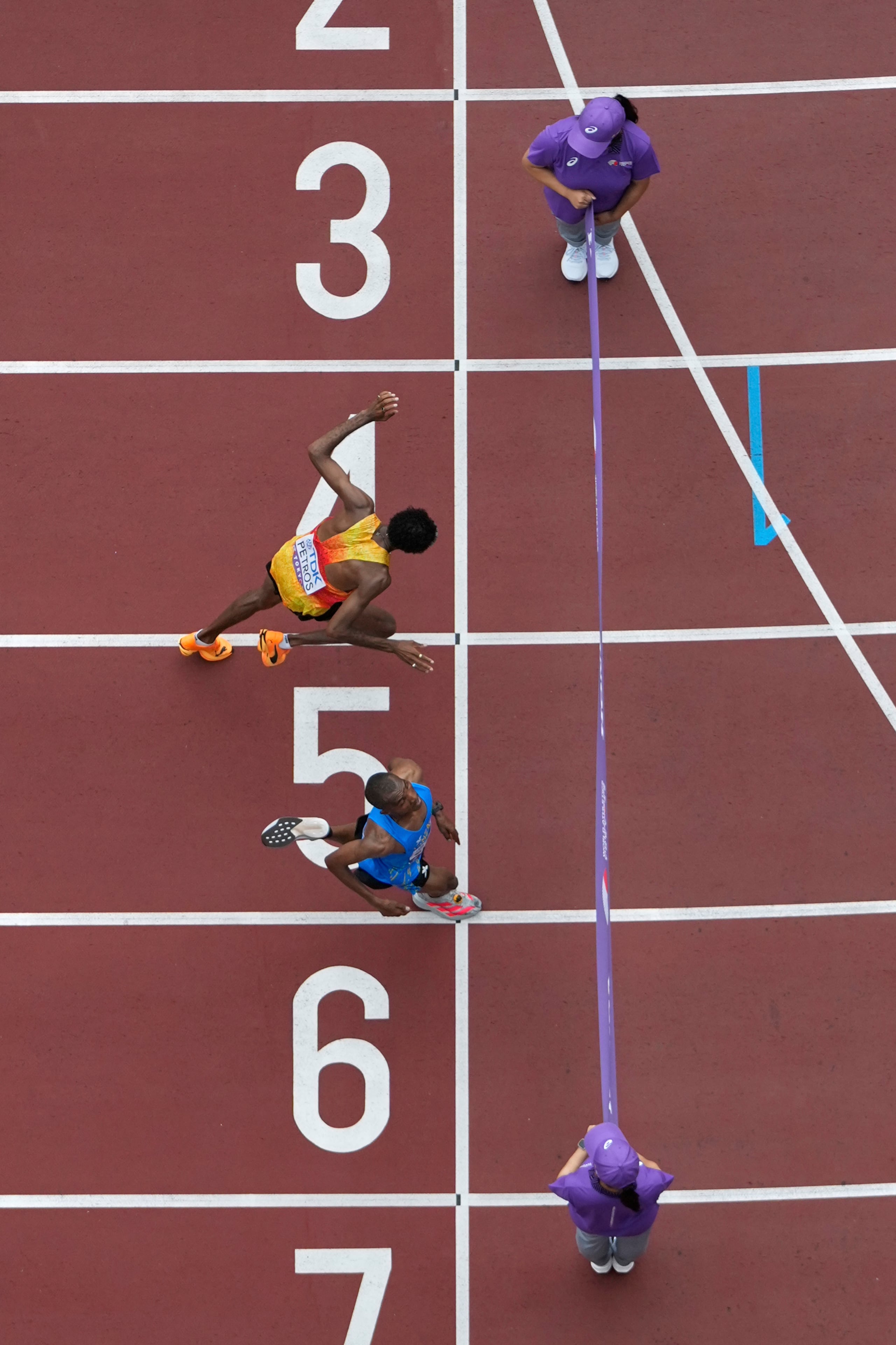 El tanzano Alphonce Felix Simbu, abajo, cruza la línea de meta por delante del alemán Amanal Petros para ganar el maratón masculino en el Campeonato Mundial de Atletismo en Tokio, el lunes 15 de septiembre de 2025.