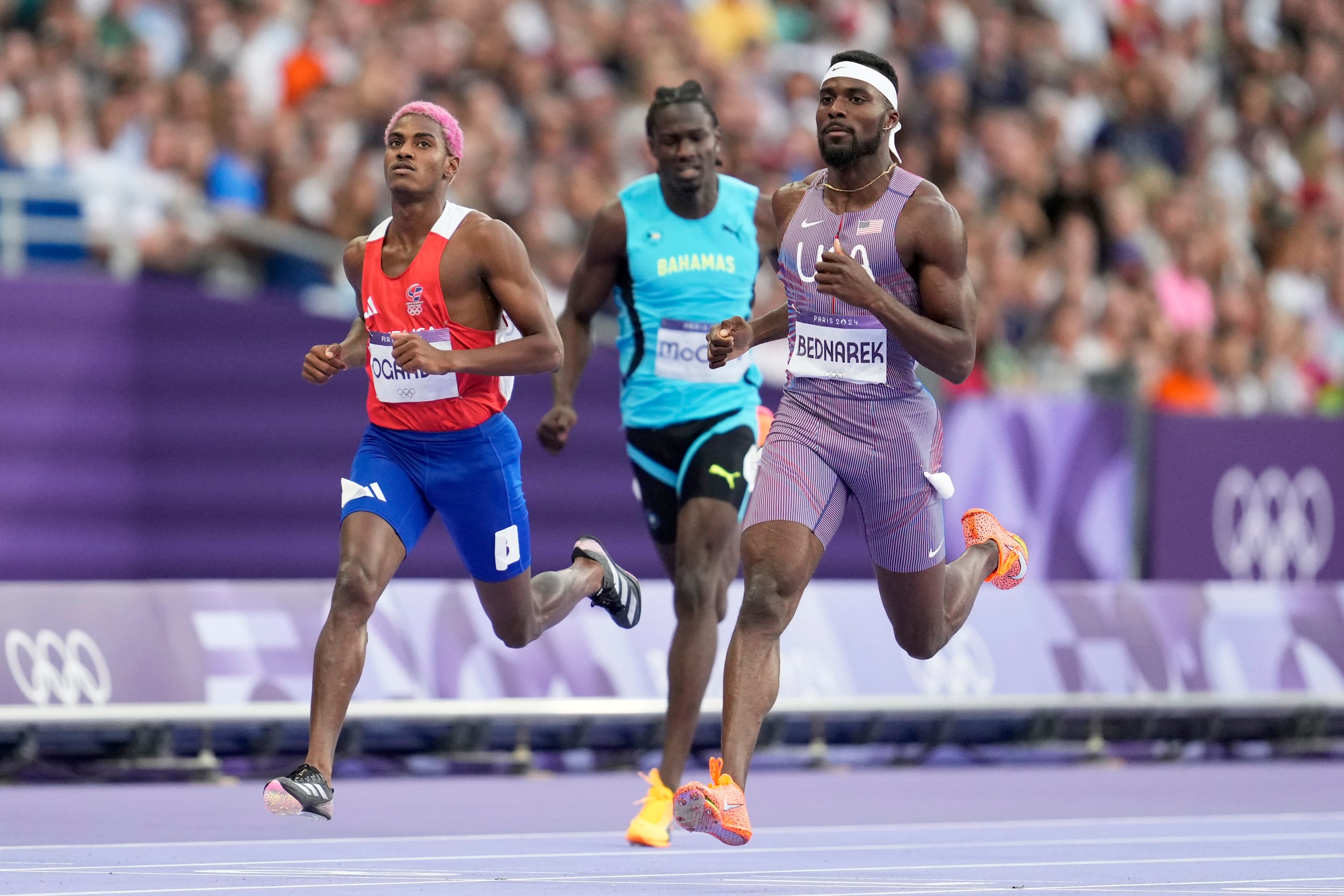 Kenneth Bednarek, de Estados Unidos, cruza la meta en los 200 metros seguido por el dominicano Alexander Ogando (izquierda), de la República Dominicana, en los Juegos Olímpicos de París 2024.