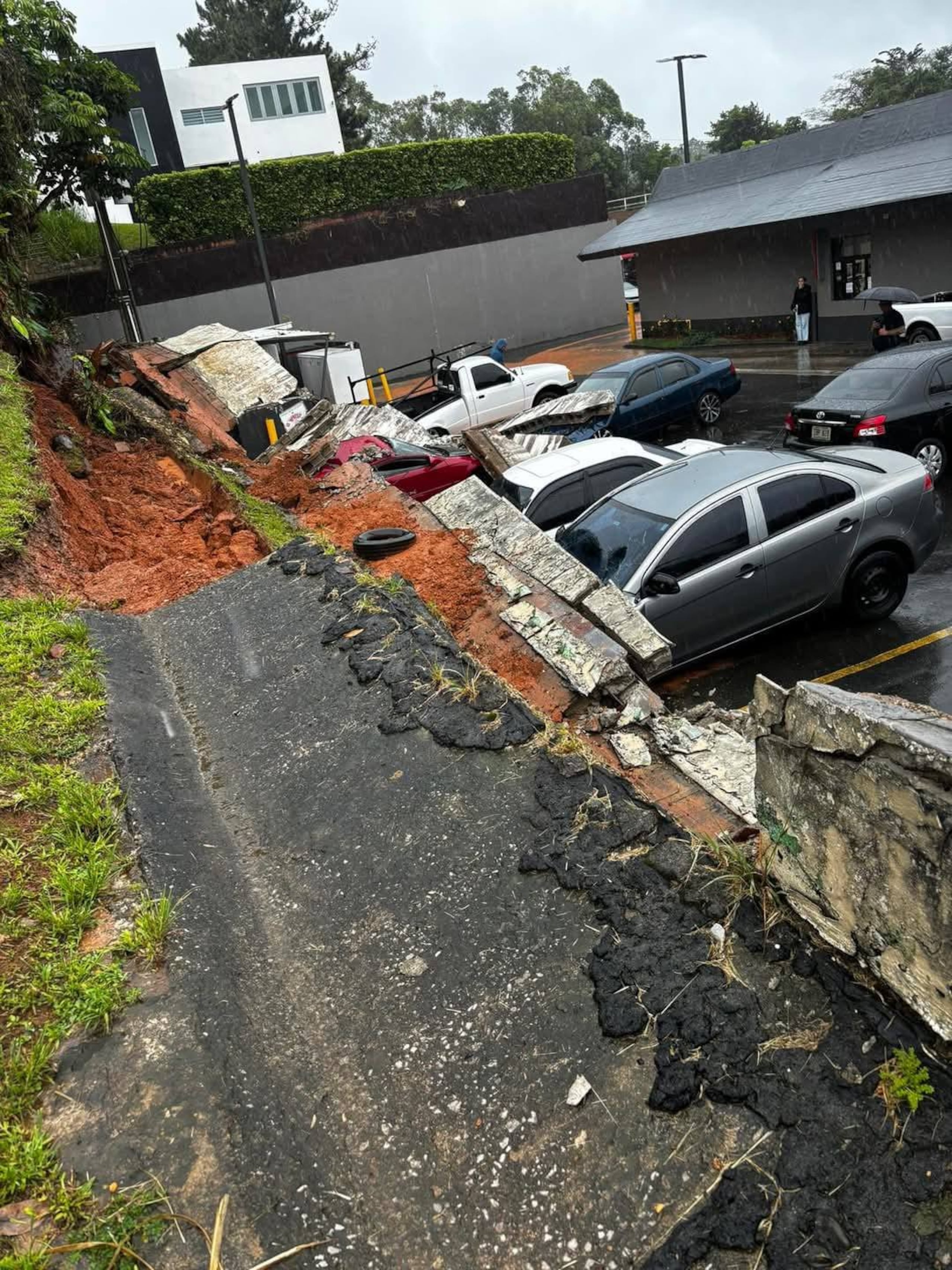 El derrumbe de un muro de contención en el estacionamiento del McDonald's del Naranjito Shopping Village dejó cuatro vehículos sepultados bajo los escombros.