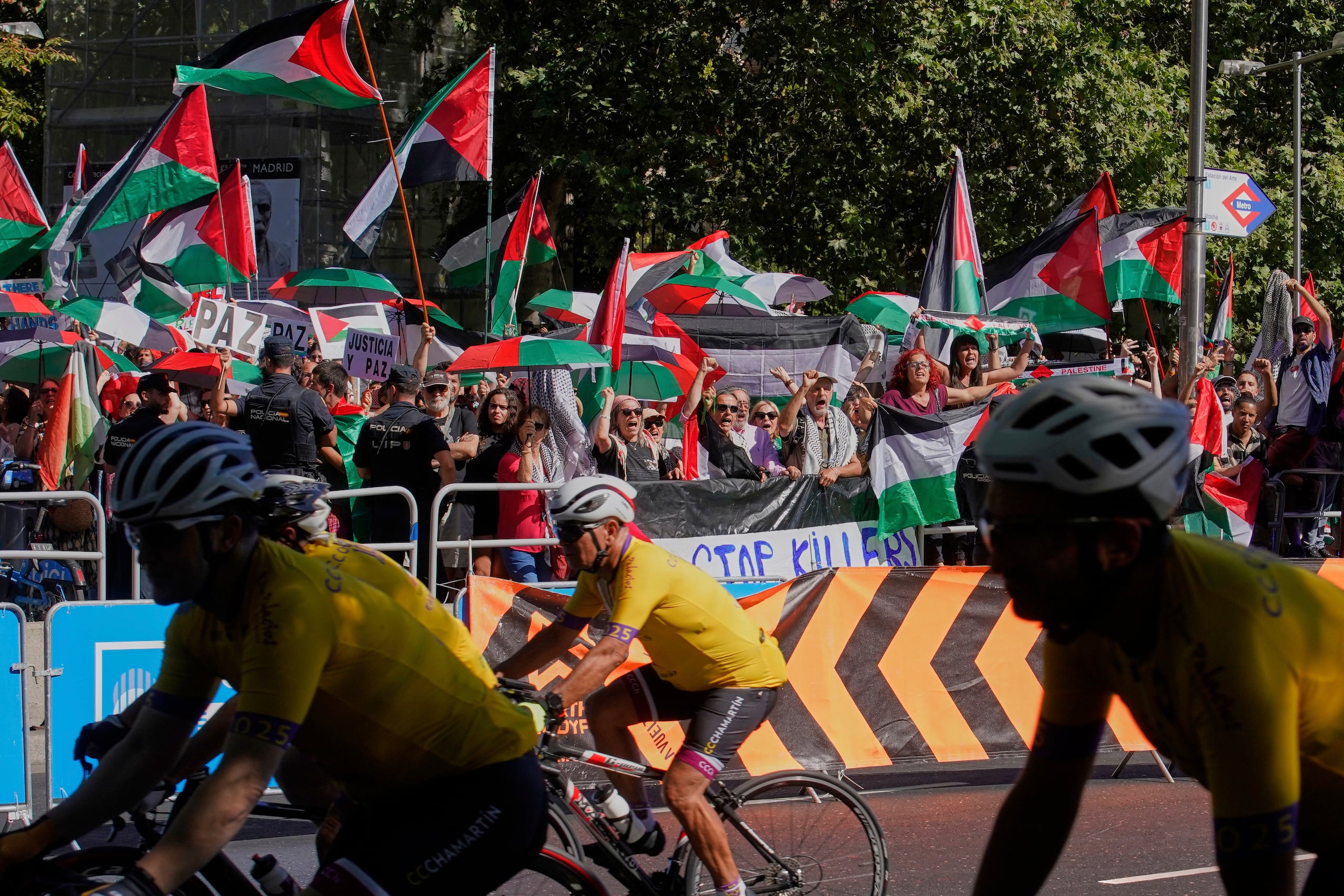 Manifestantes con banderas pro-Palestina protestan durante la 21ma y última etapa de la Vuelta a España minetras circulan los ciclistas entre Alalpardo y Madrid el domingo 14 de septiembre del 2025.. (AP Foto/Andrea Comas)