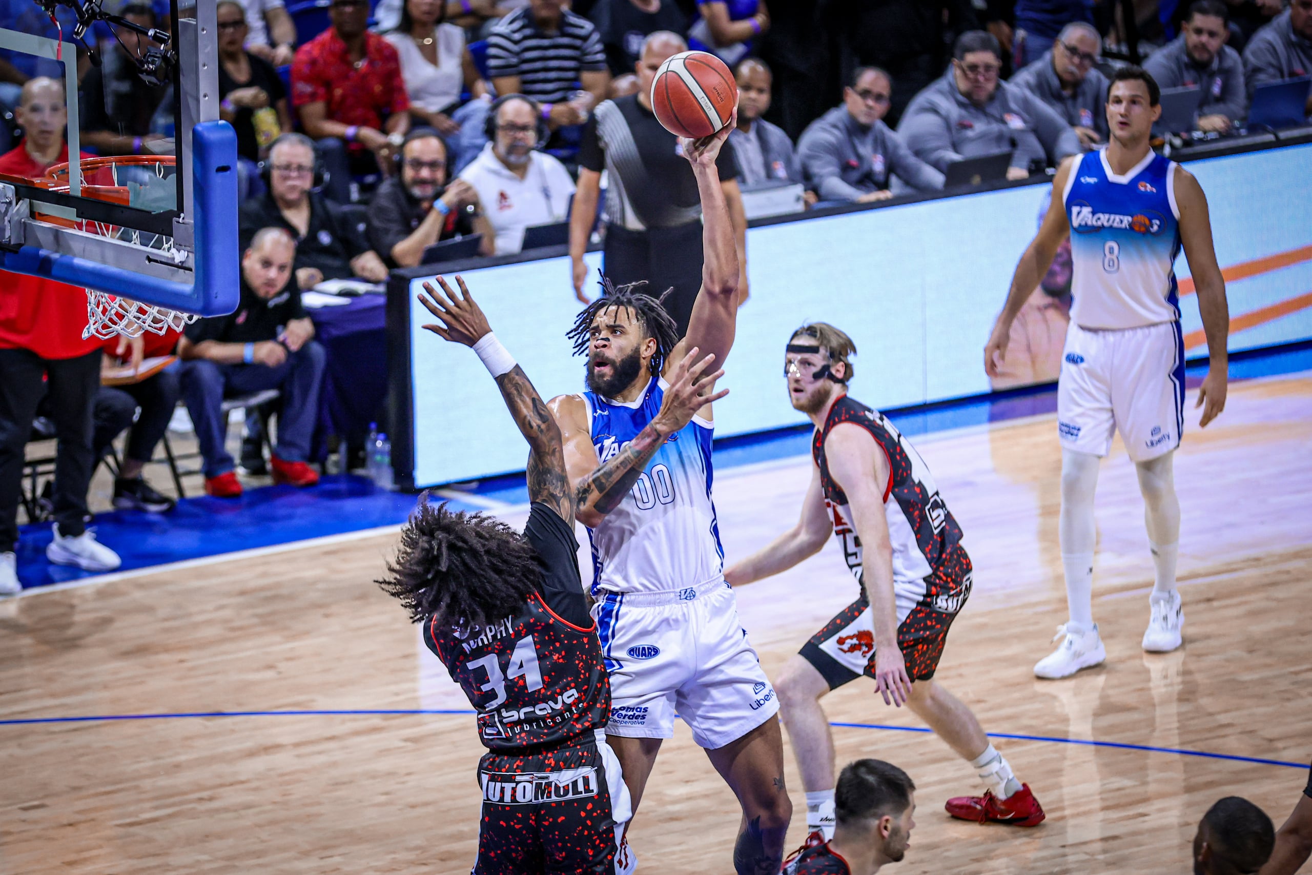 JaVale McGee, refuerzo de los Vaqueros, ataca el canasto frente a Jordan Murphy, de los Leones de Ponce, en la final 2025 del BSN.