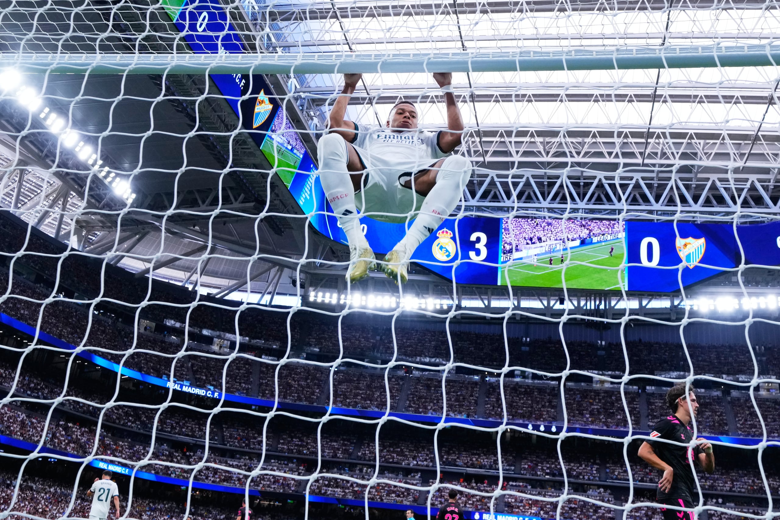 El delantero del Real Madrid Kylian Mbappé se cuelga del poste durante el partido contra Málaga.