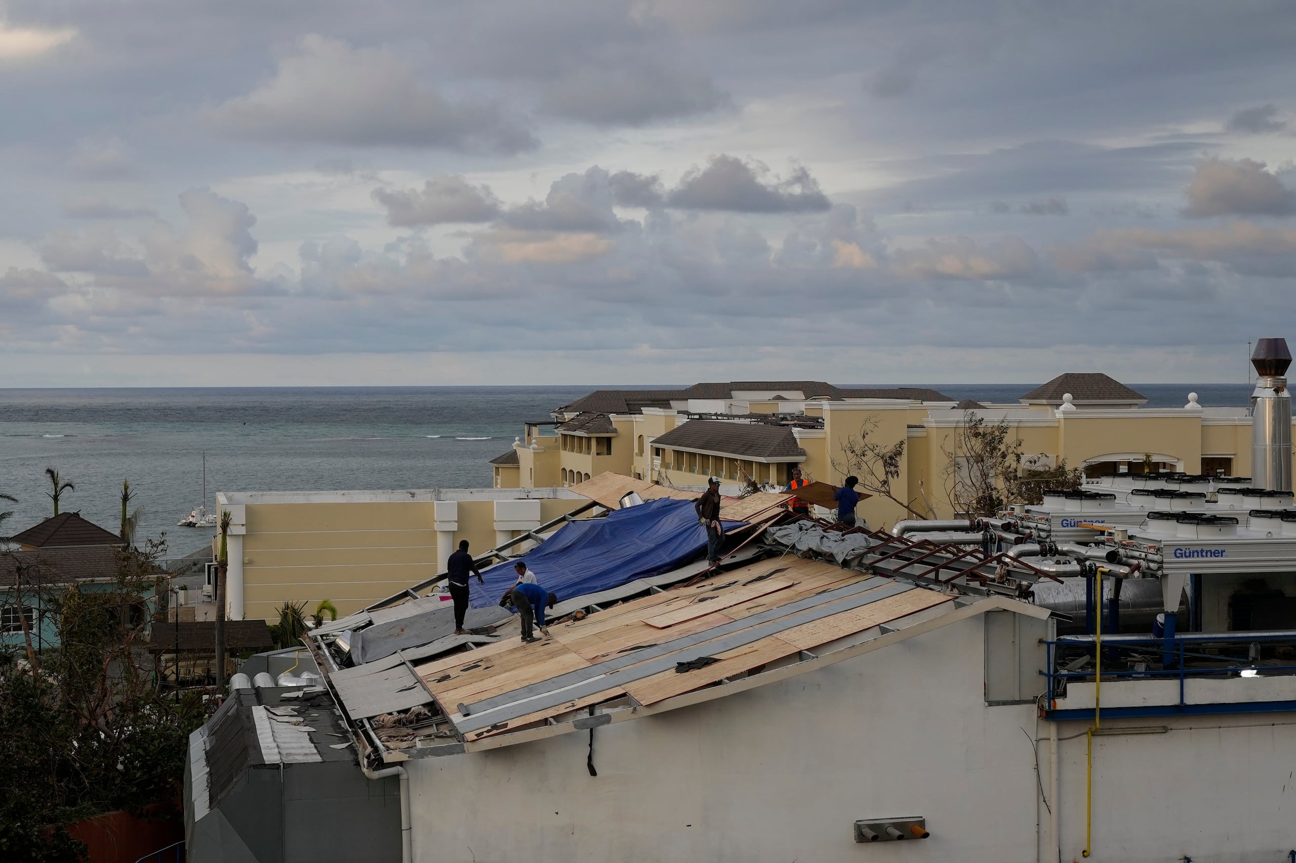 Personas reparan el techo de un resort en Montego Bay, Jamaica, el 31 de octubre del 2025, tras el paso del huracán Melissa.