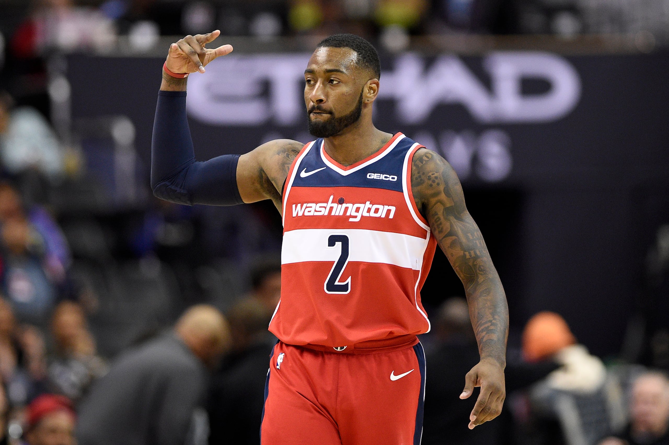 John Wall en uniforme de los Wizards de Washington hace un gesto al encestar un triple.
