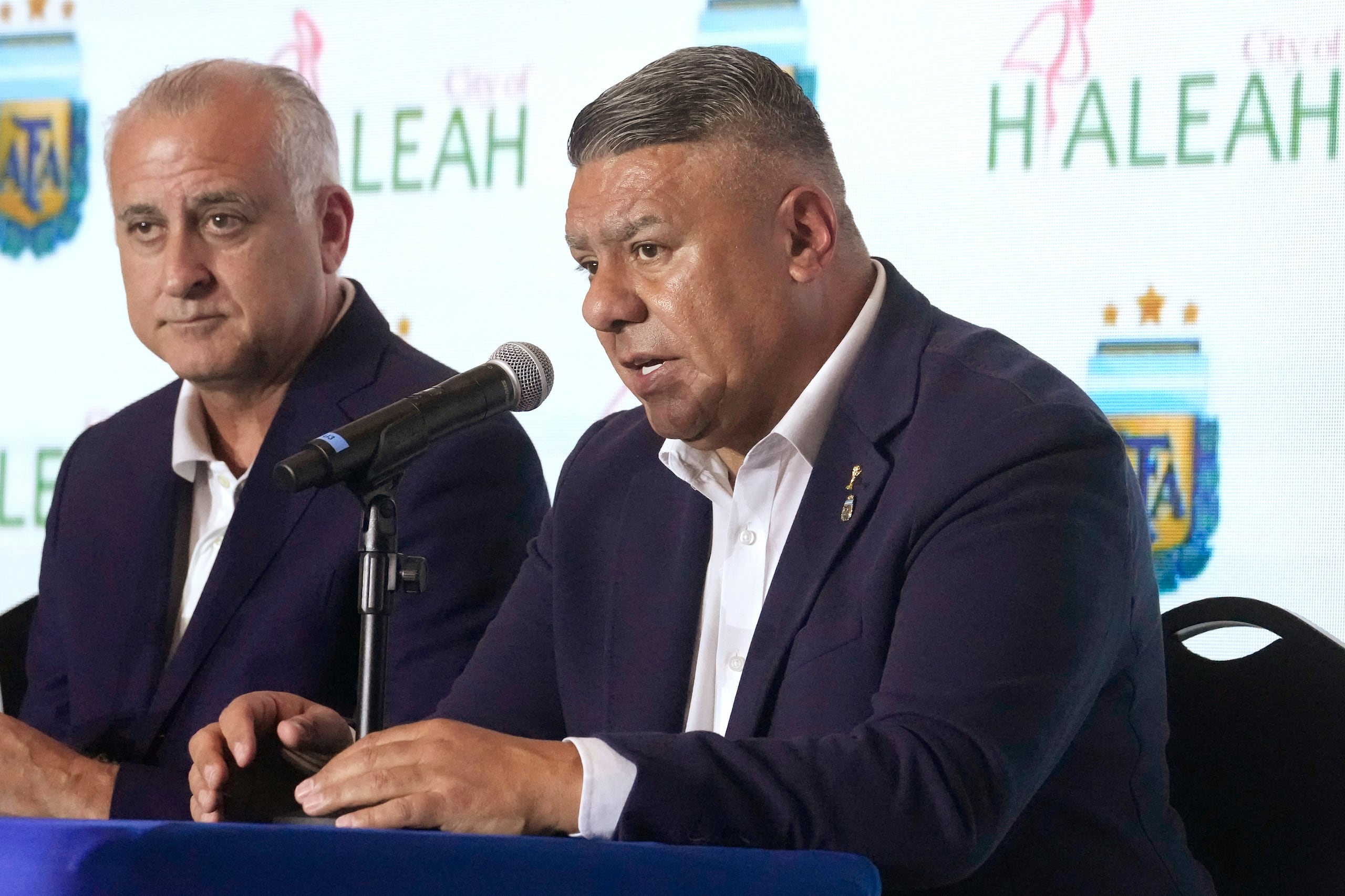 Claudio Tapia, presidente de la Asociación del Fúltbol Argentino, habla durante una rueda de prensa en la que anunció planes de construir un centro de entrenamiento de alto rendimiento en el área de Miami, el martes 15 de agosto de 2023, en Hialeah, Florida. La expansión de la AFA en Estados Unidos incluye también una academia para divisiones inferiores. A la izquiera el alcalde de Hialeah, Esteban Bovo. (AP Foto/Marta Lavandier)