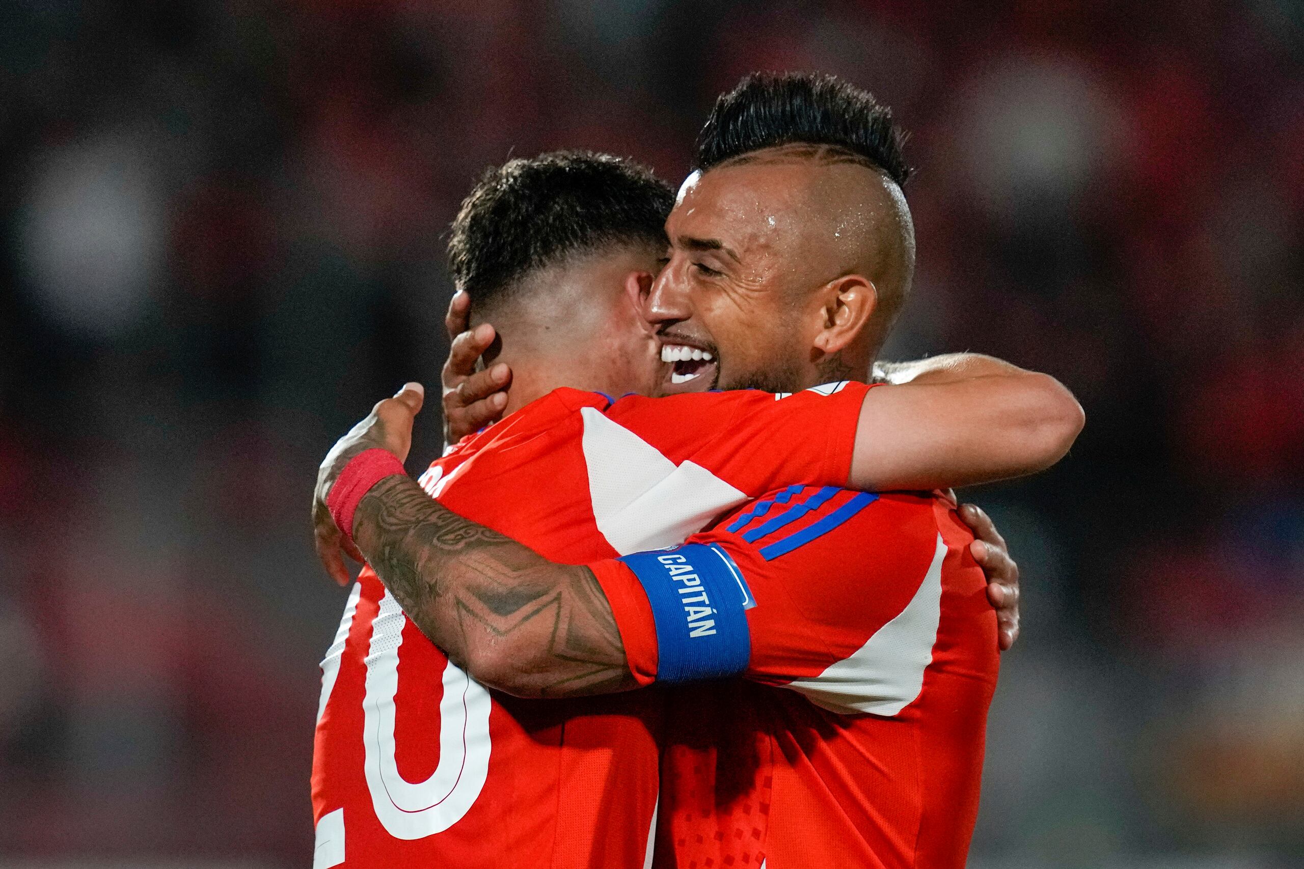 Lucas Zepeda (izquierda) festeja su gol con su compañero de la selección de Chile, Arturo Vidal, durante un encuentro de la eliminatoria al Mundial ante Venezuela, el martes 19 de noviembre de 2024, en Santiago (AP Foto/Esteban Félix)