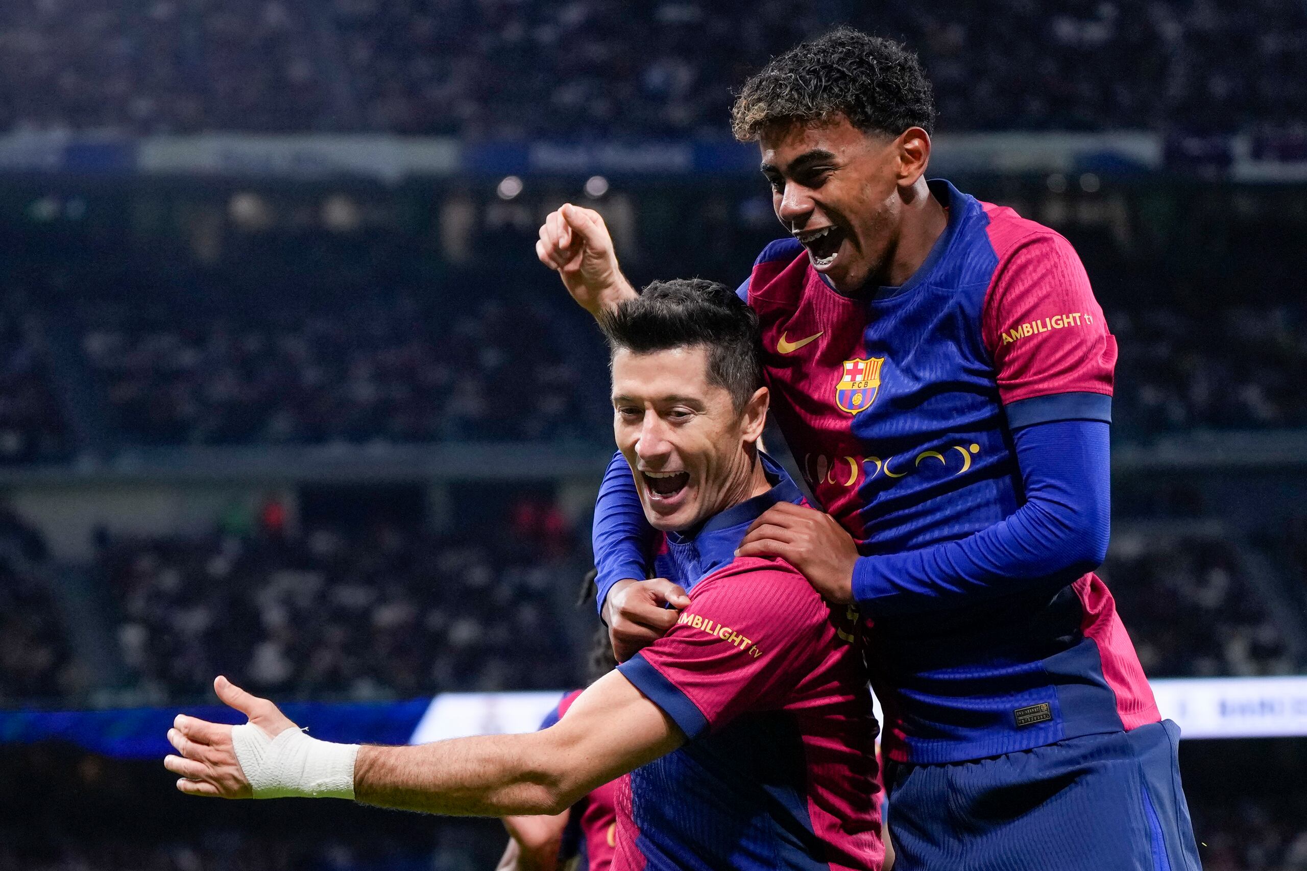 Robert Lewandowski, del Barcelona, celebra después de anotar el segundo gol de su equipo con Lamine Yamal, a la derecha, durante el partido contra el Real Madrid.