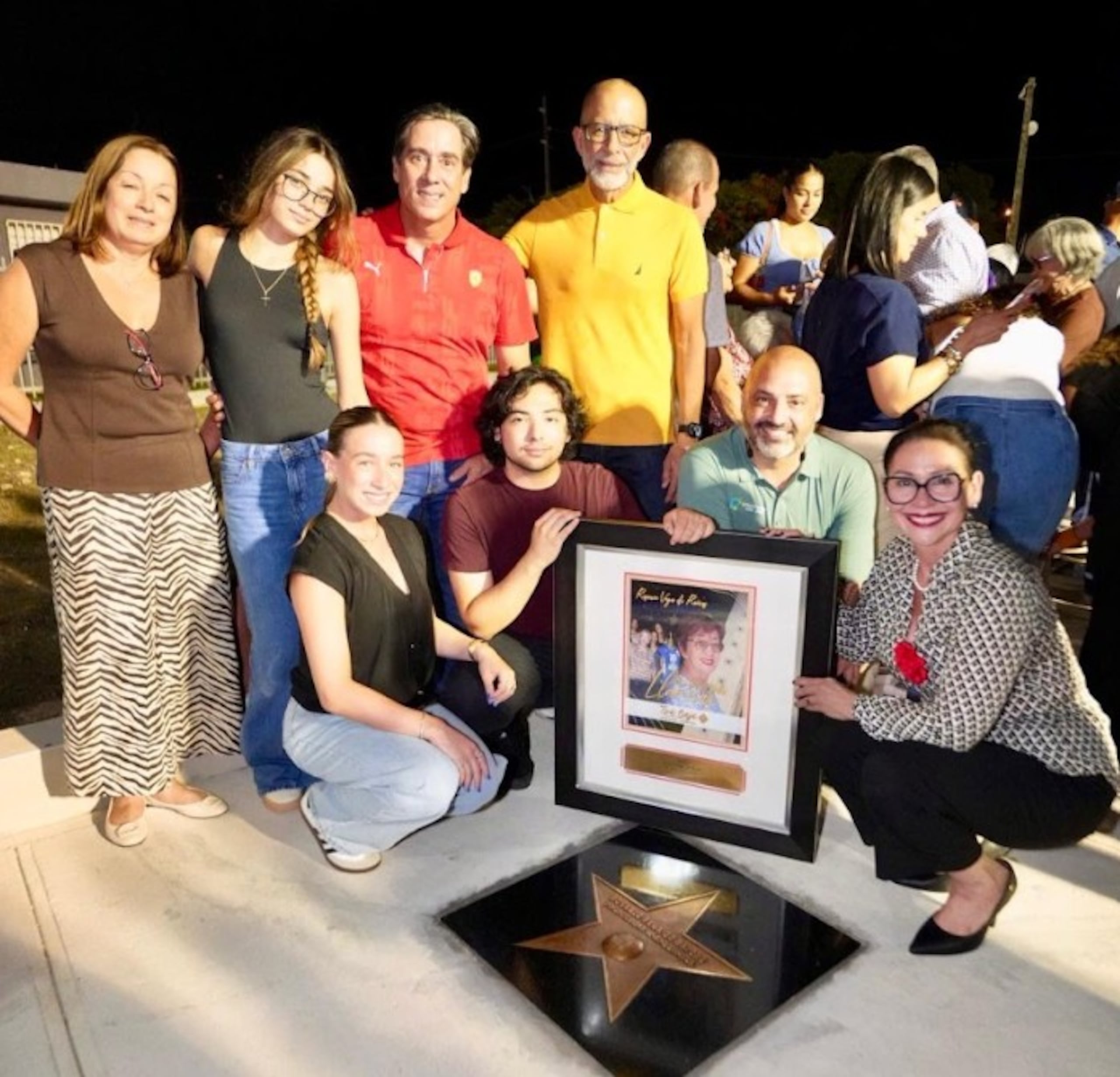 Los hijos, nietos y otros familiares de Rosario Vega de Raíces (qepd), sonríen al posar para la foto frente a la estrella develada en su honor. Vega de Raíces fue una gestora del voleibol en Toa Baja y fundadora de las Llaneras de la Liga de Voleibol Superior.