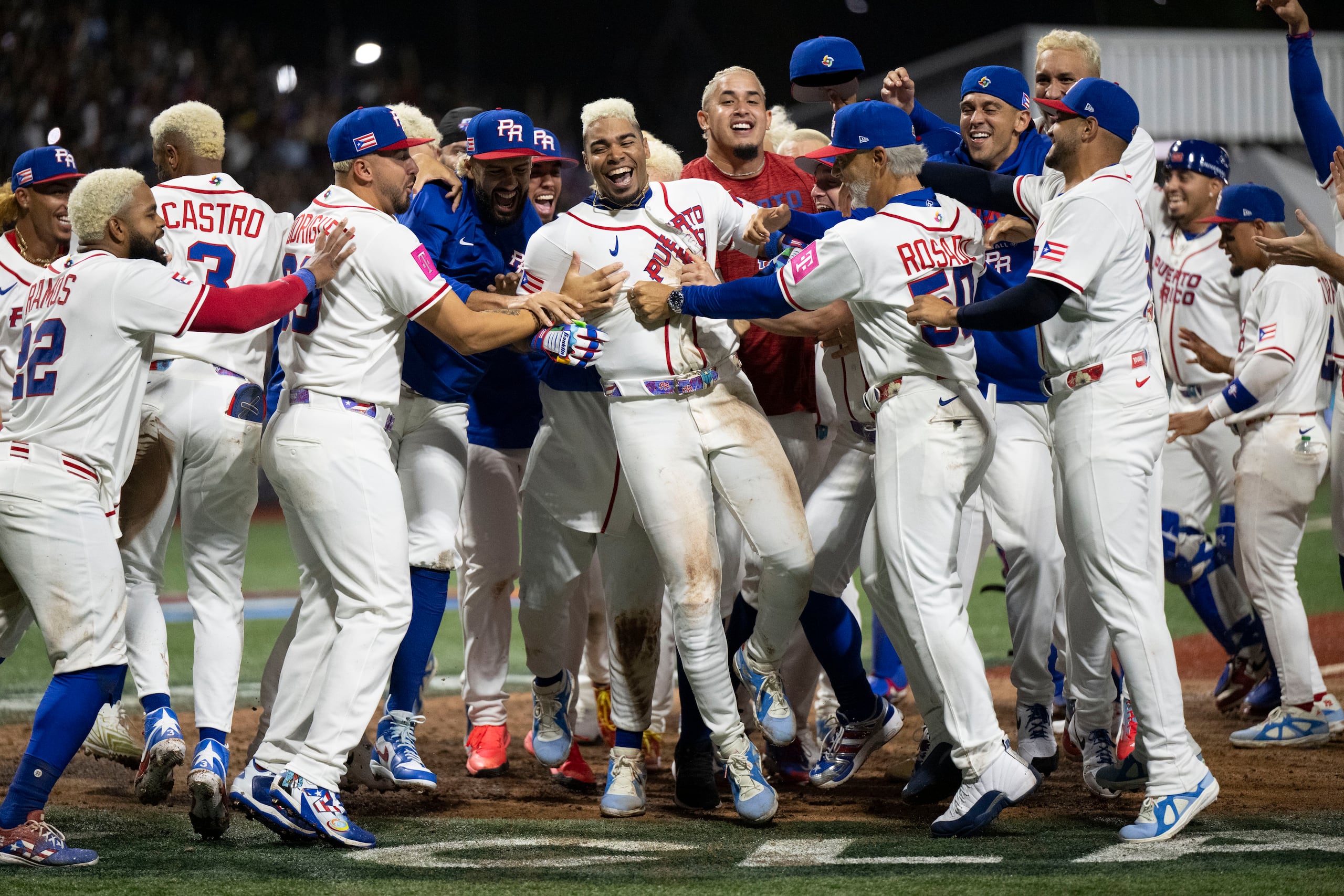 Darell Hernaiz festeja con sus compañeros de equipo a su llegada al plato, tras darle la victoria 4-3 a los boricuas en entradas extras.
